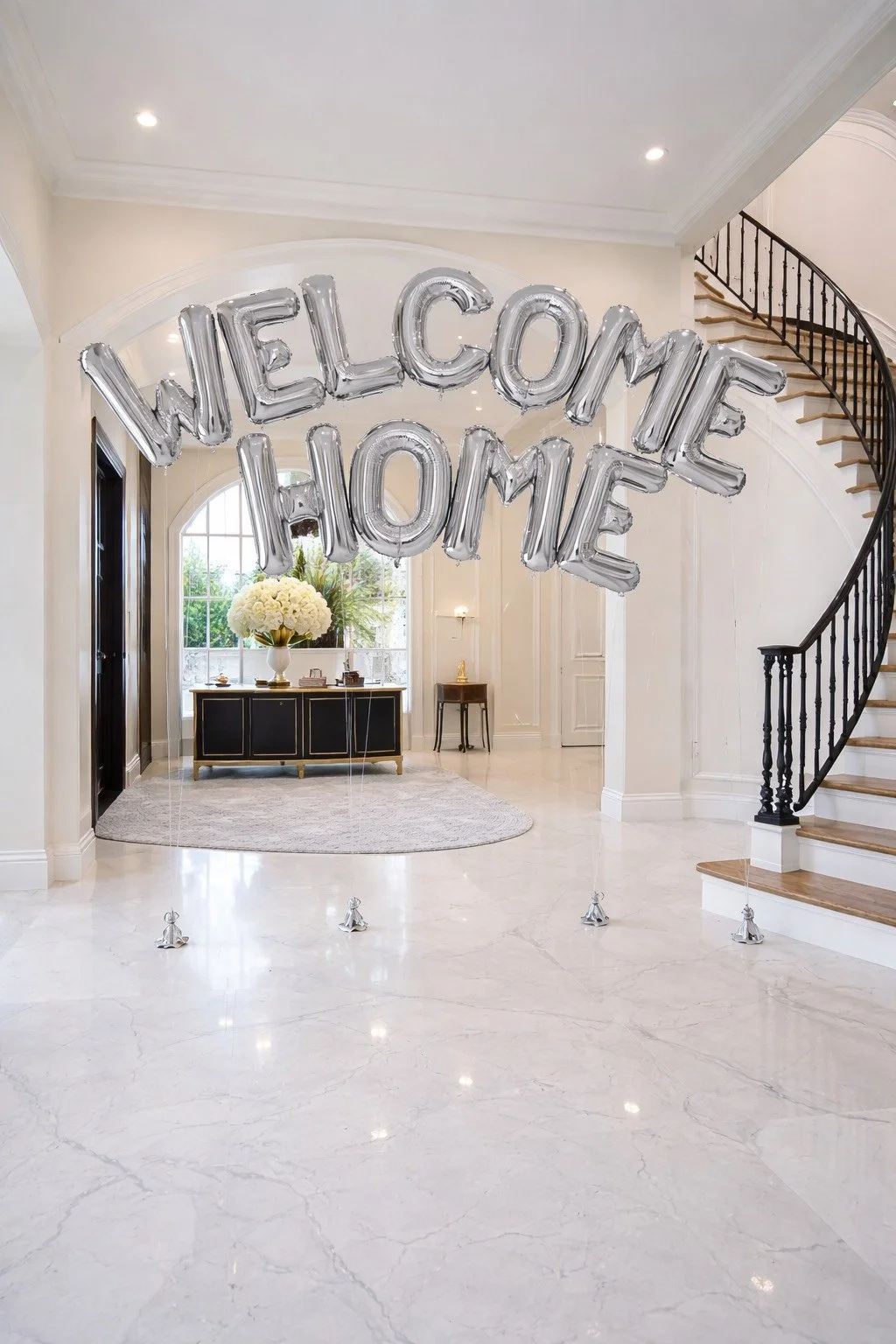 Interior of a home with a welcome decoration, including silver balloons spelling out "WELCOME HOME".