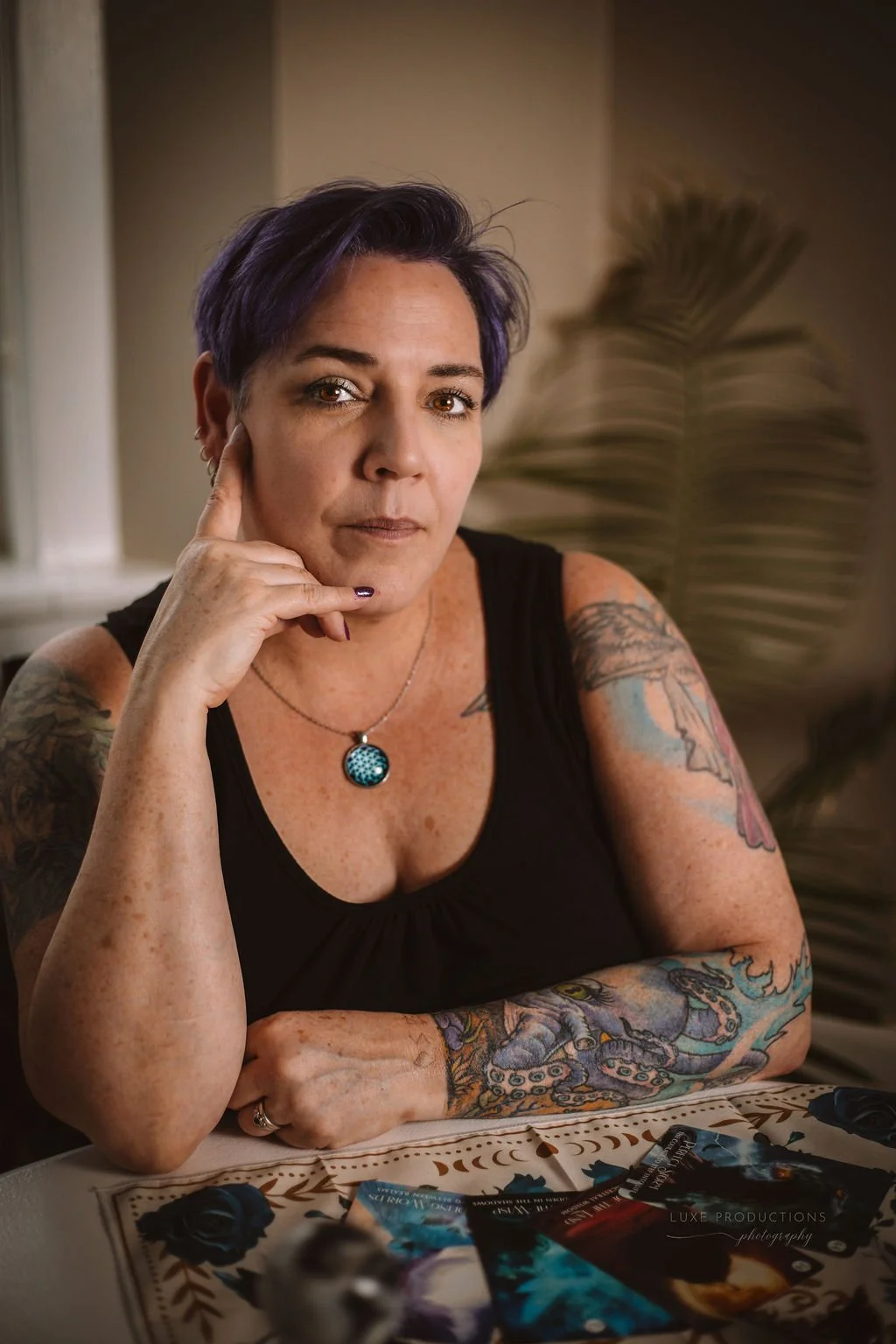 A picture of me sitting at a table with my hand resting under my chin looking at the camera.