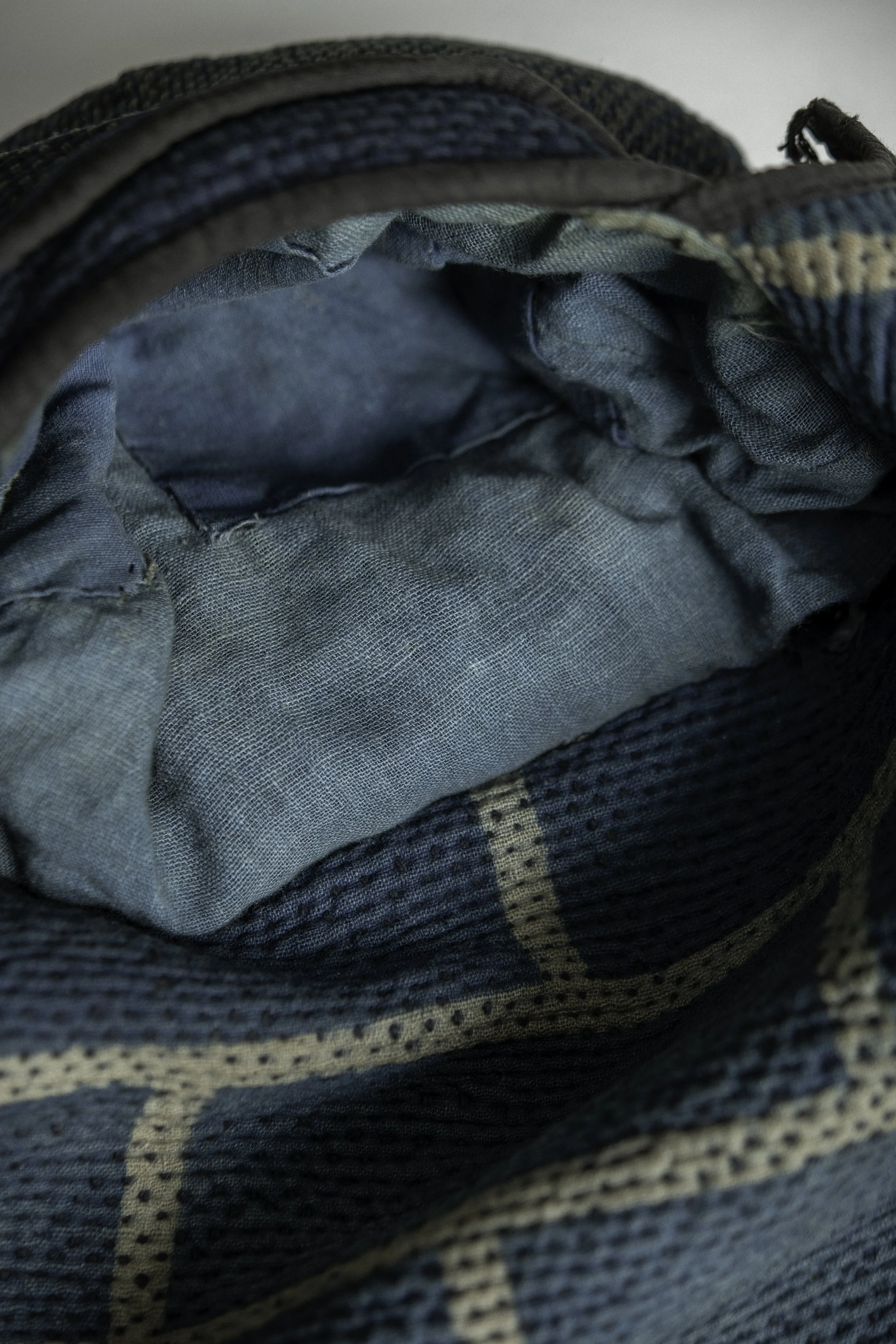 interior of a Meiji period Japanese fireman's hood showing padded crown and kasuri-checked lining.