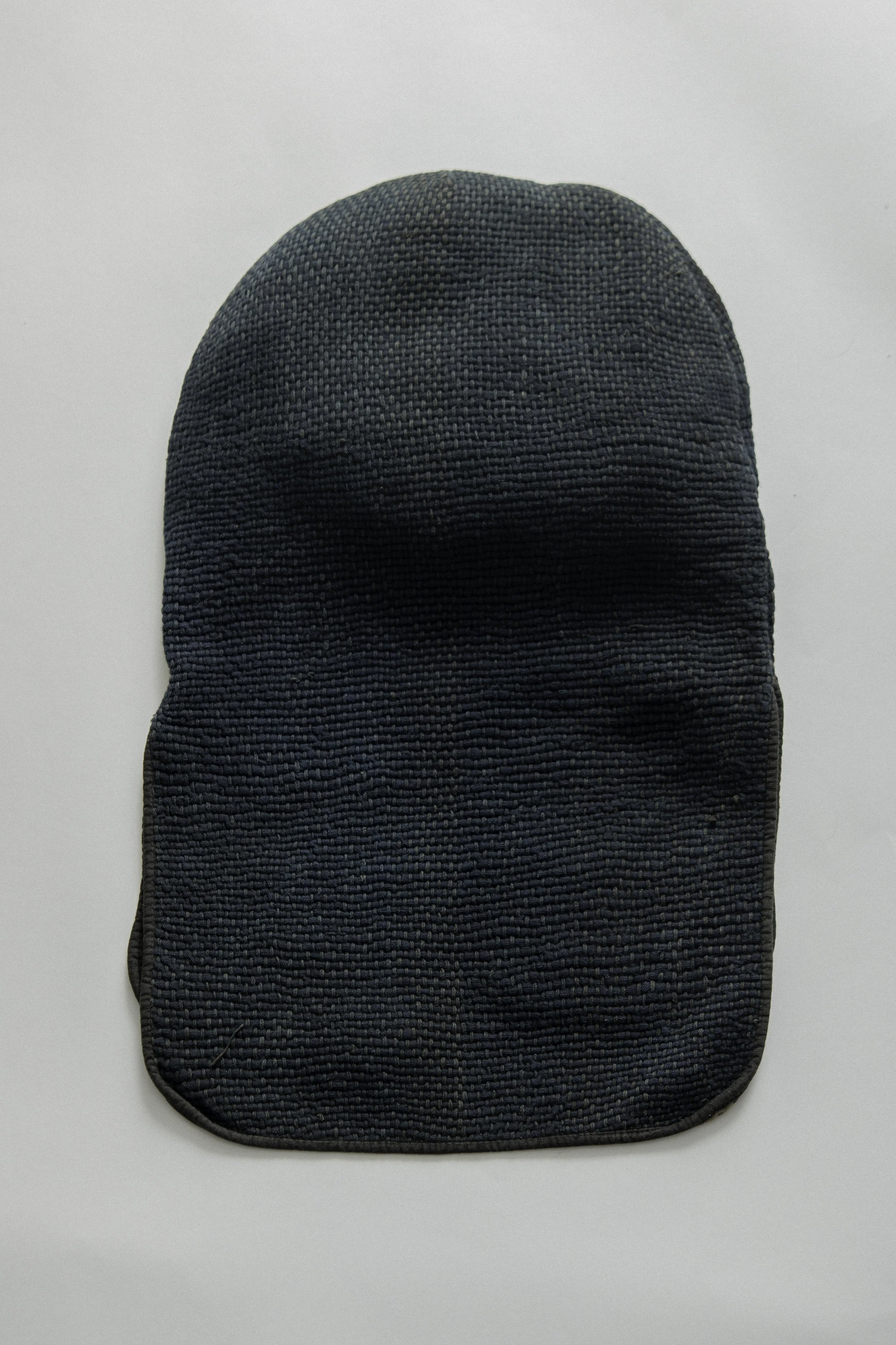 Rear view of a Japanese indigo-dyed sashiko hikeshi zukin with quilted neck flaps.