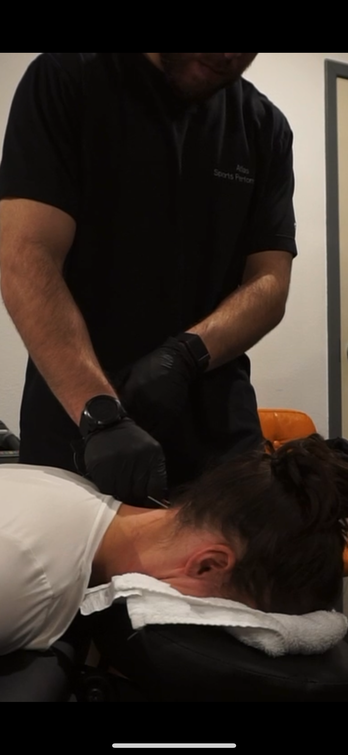 Person receiving a medical injection from a healthcare professional in a clinical setting.