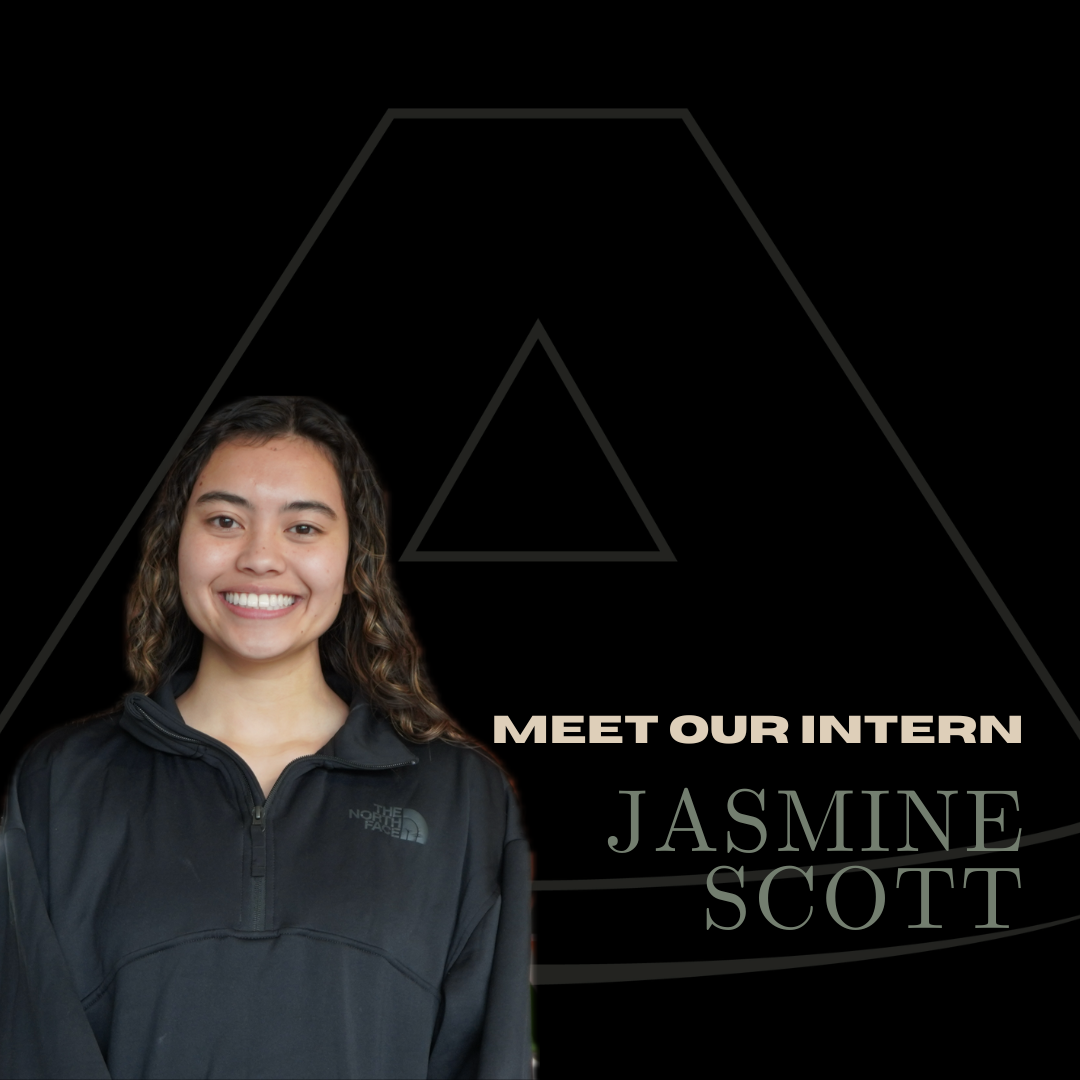 Young woman with brown curly hair smiling, wearing a black North Face jacket, with text 'Meet Our Intern Jasmine Scott' on a black background.