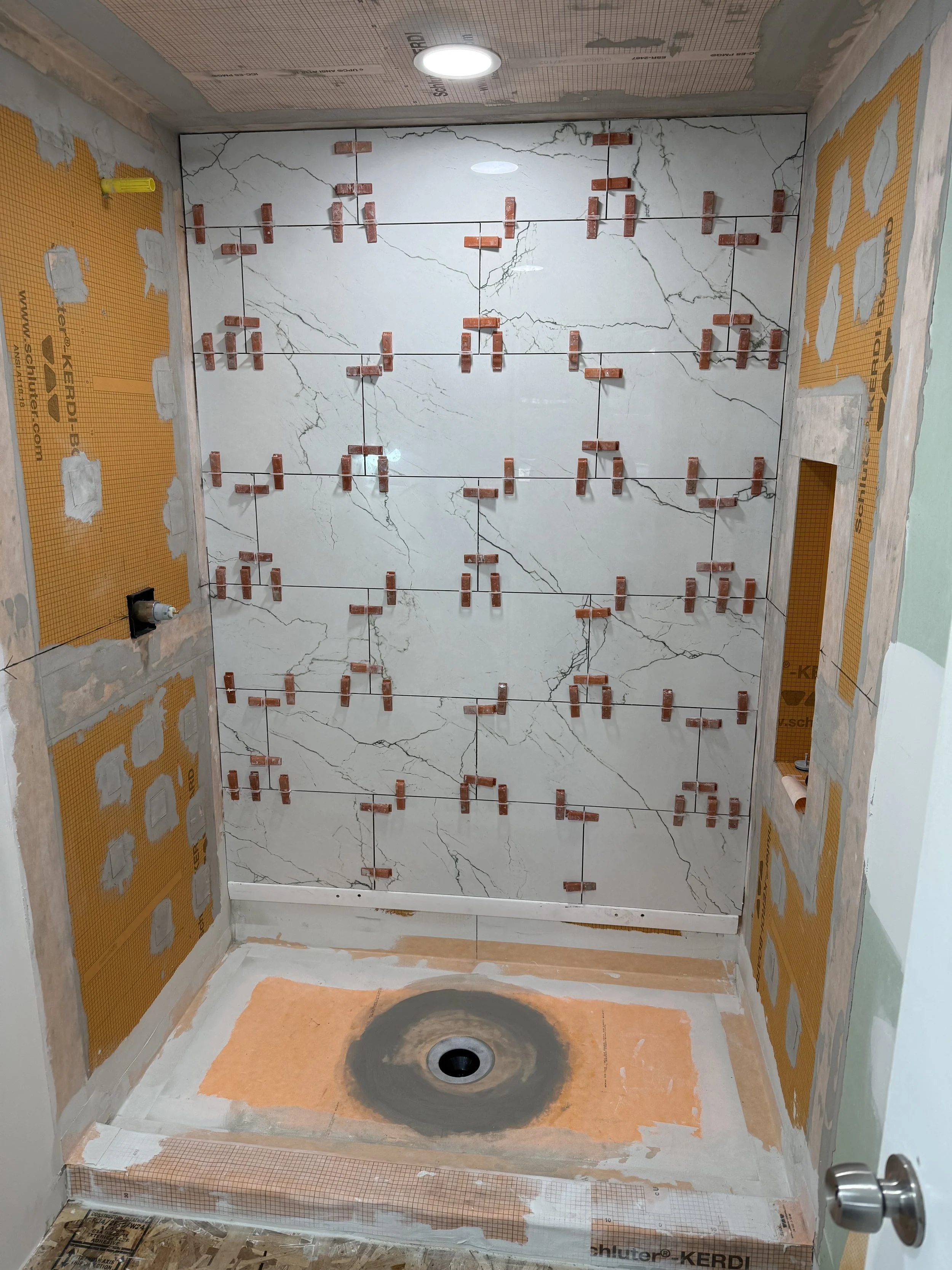 A progress photo of a Glen Holman Contracting bathroom remodel showing tiling.