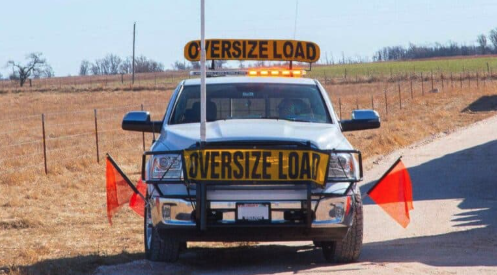 Three refrigerated semi-truck trailers parked in a lot during sunset, with a cloudy sky overhead.