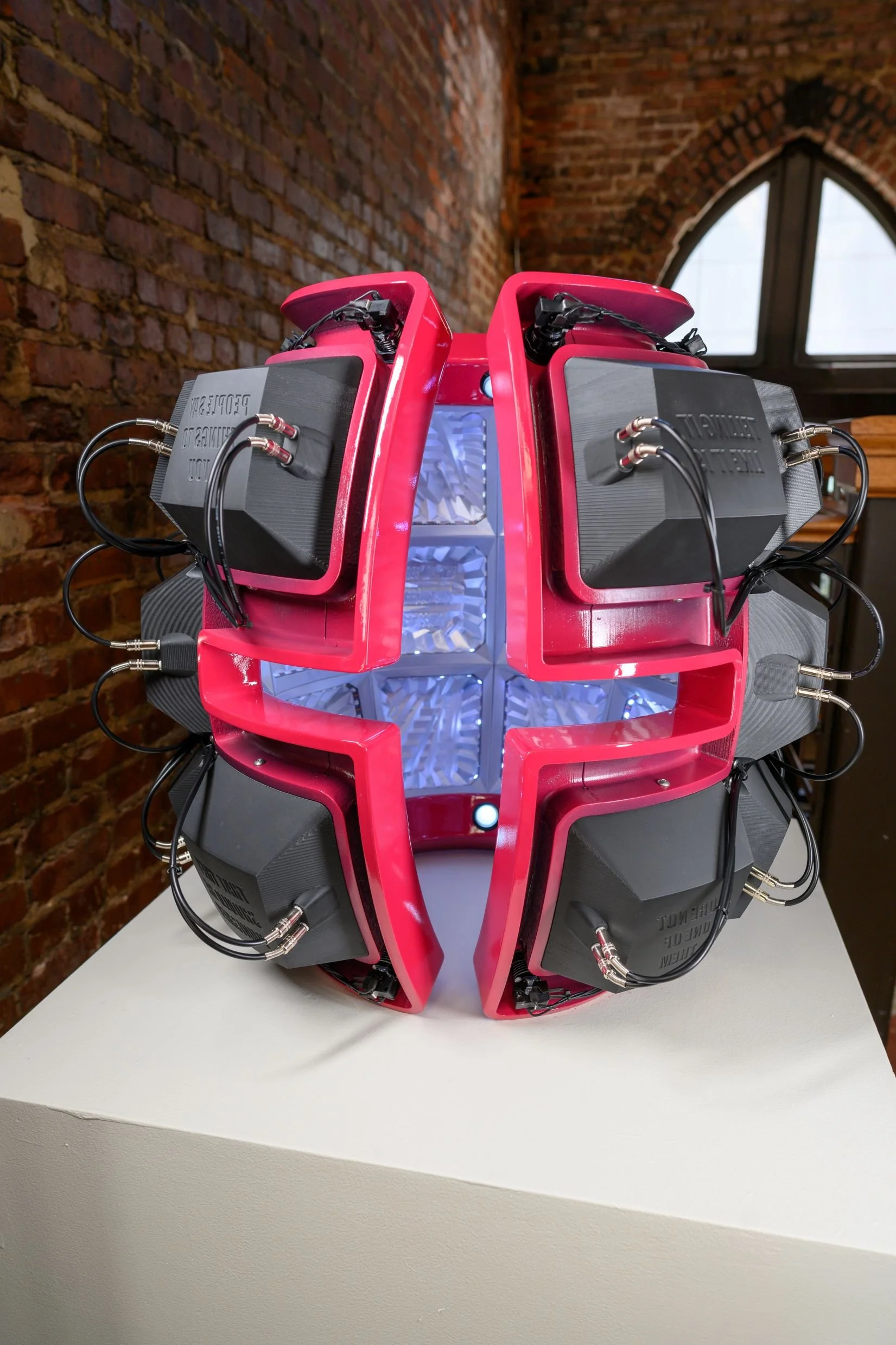 PINK SHELL sits on a white pedestal showing the final wiring, pink frame, black exterior cells, and chrome interior cells.