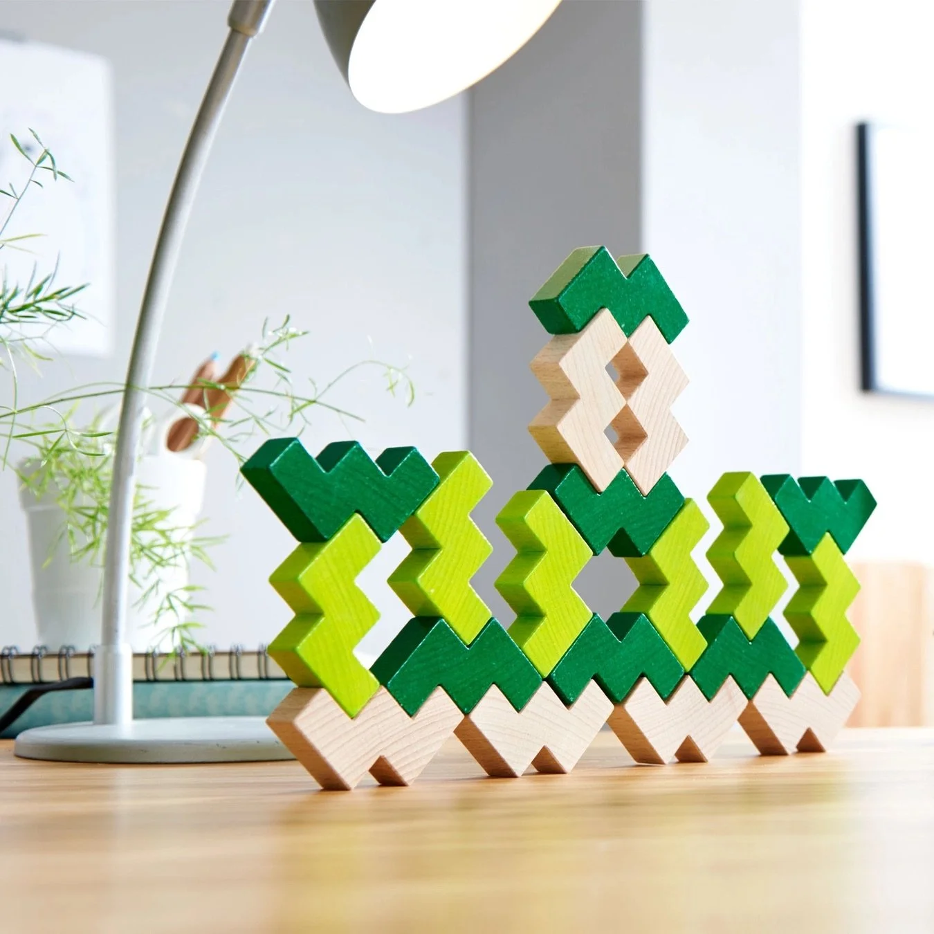 Light green, dark green, and natural wooden blocks stacked in a pattern