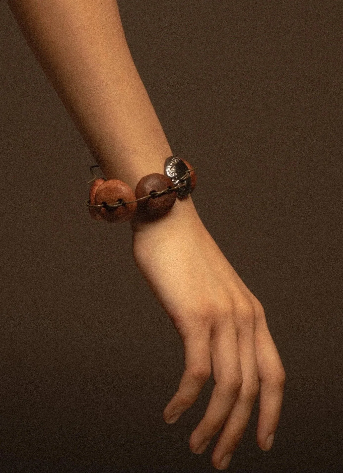 Bracelet 'Made In_' features a silver button replacing a missing wooden one, honouring the original through durable material while acknowledging it can never be the same. Marked ‘Made in London,’ the new button adds identity and narrative, while its 
