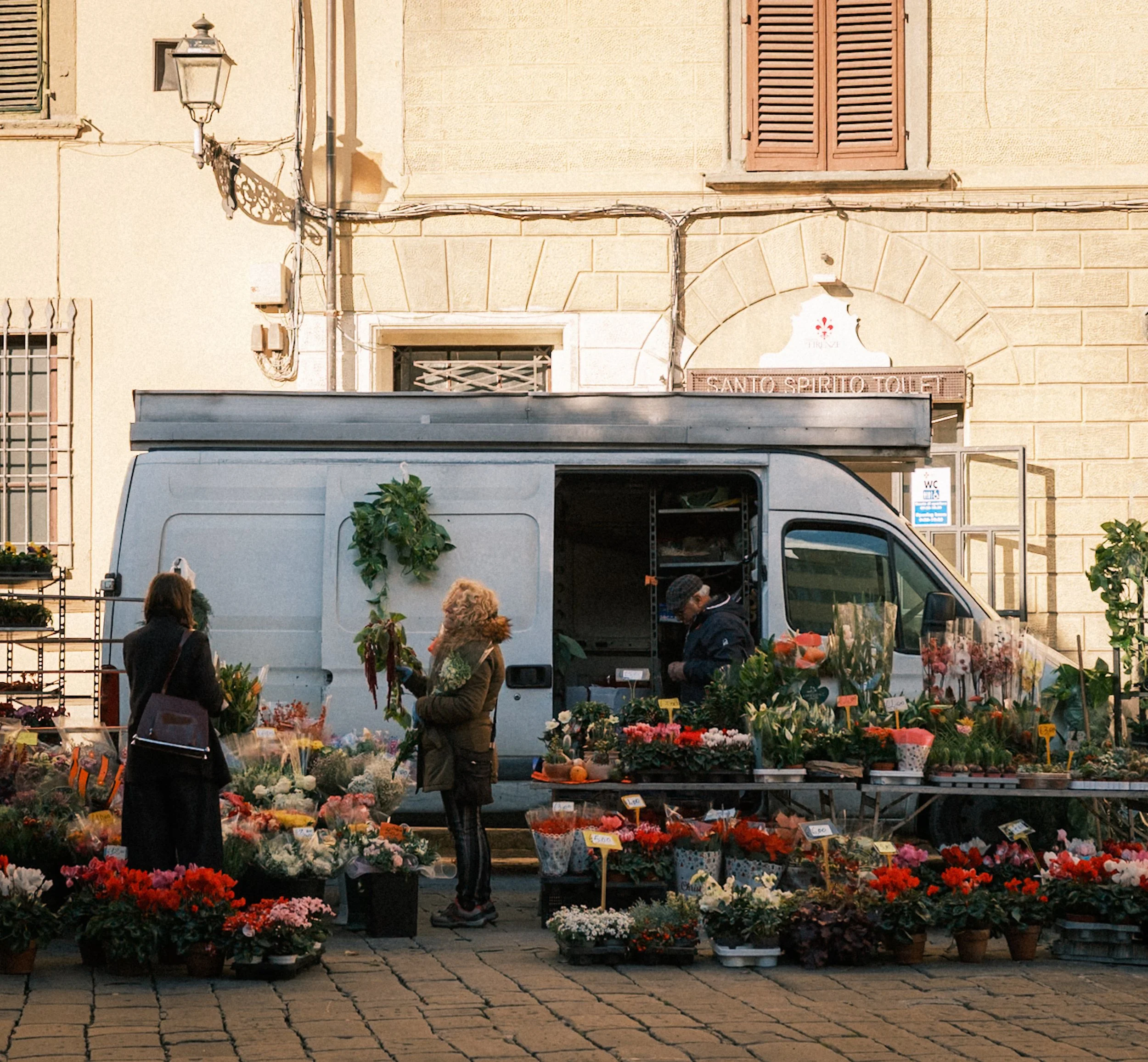 Local flower market with colorful flowers on a street in Florence