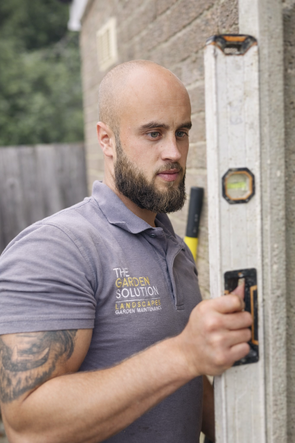 North London landscaping specialist checking levels during a high-quality garden build and installation.