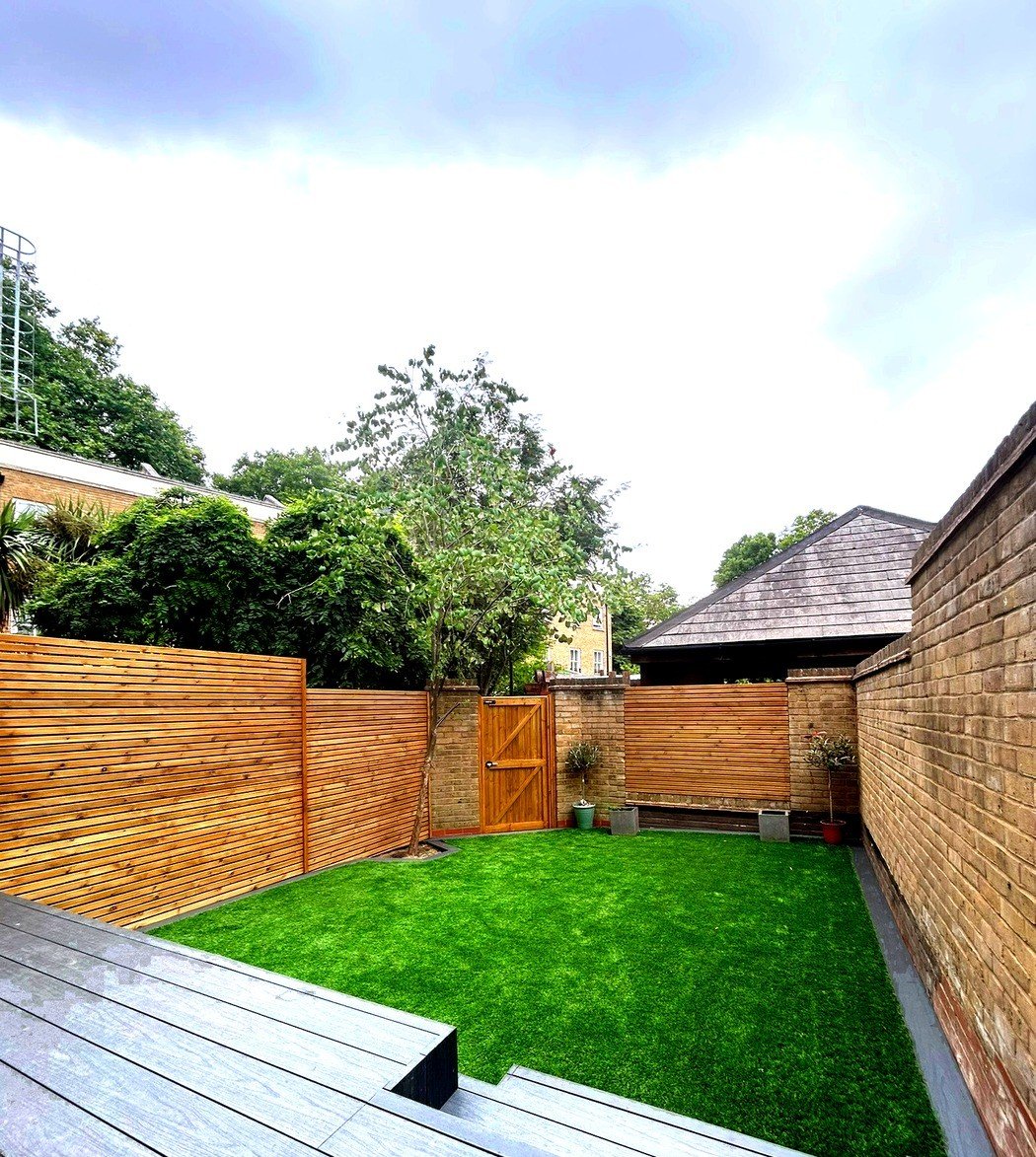 Artificial grass garden with composite decking and timber batten fencing in Islington, North London