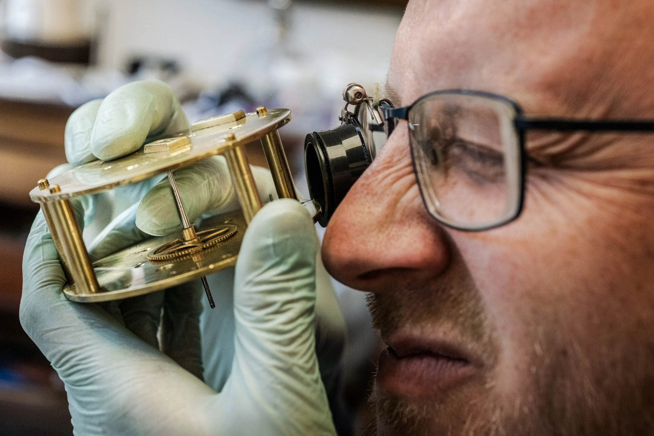 An image of Dale Sardeson examining a clock during servicing and repair. Photo © Matt Wreford Photography
