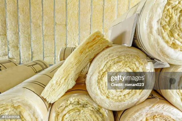 Rolls of mineral wool insulation with a cut section showing the texture.