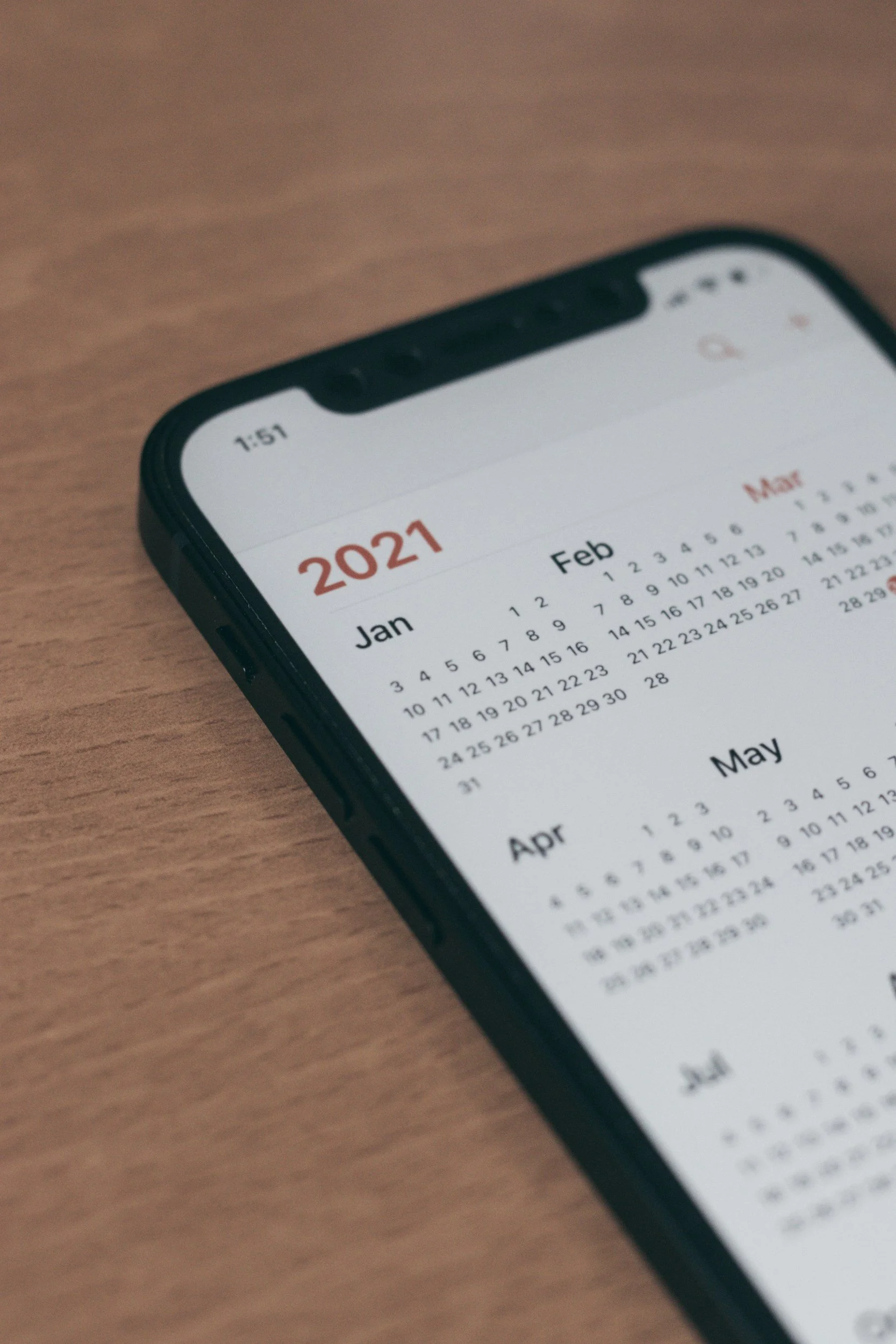 Smartphone displaying 2021 calendar on a wooden surface