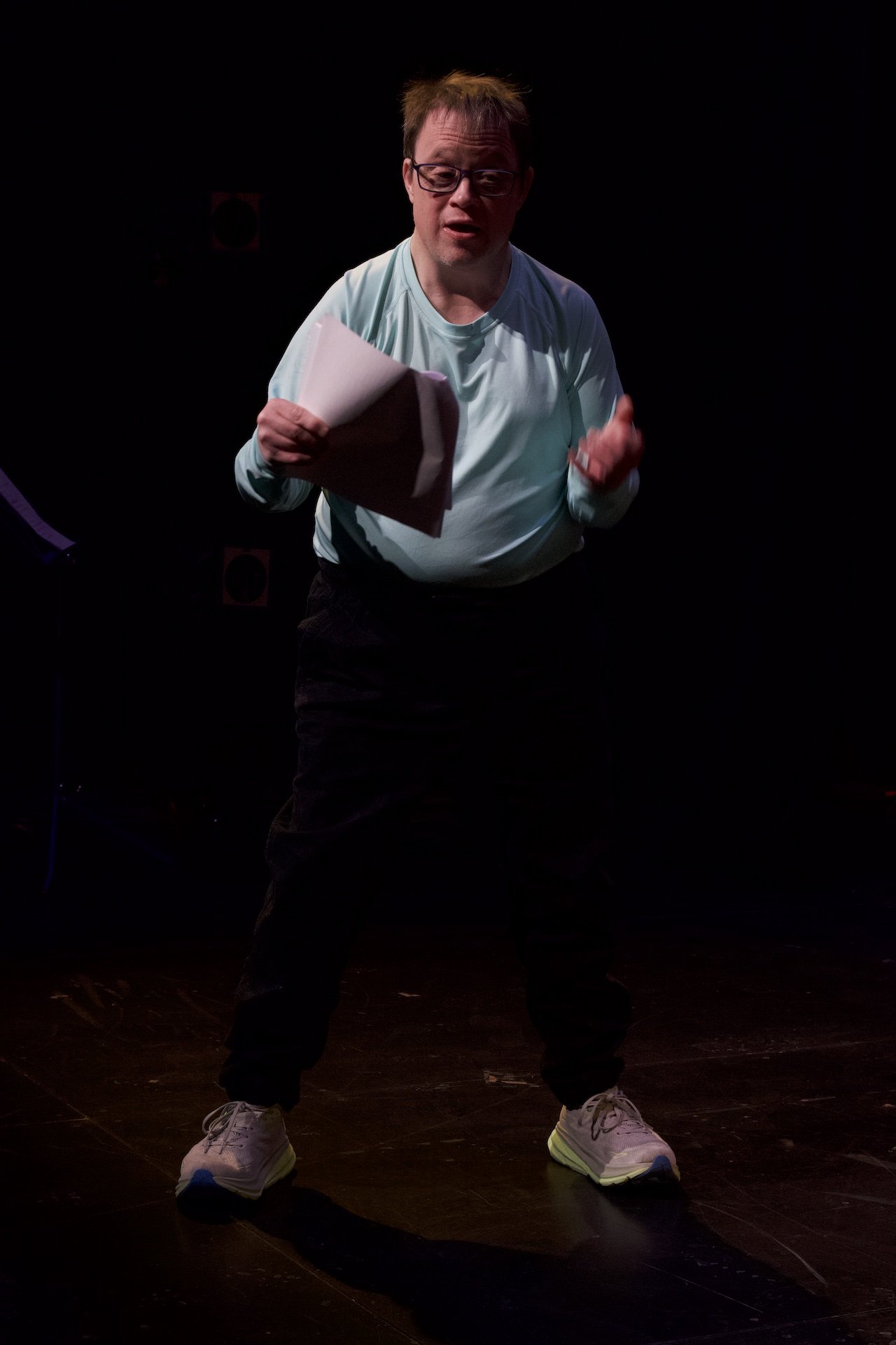 Photo of Andreas Prinz by Tyler Preece. Andreas wears a long-sleeved blue shirt, black pants and sneakers. He stands with a script in one hand.