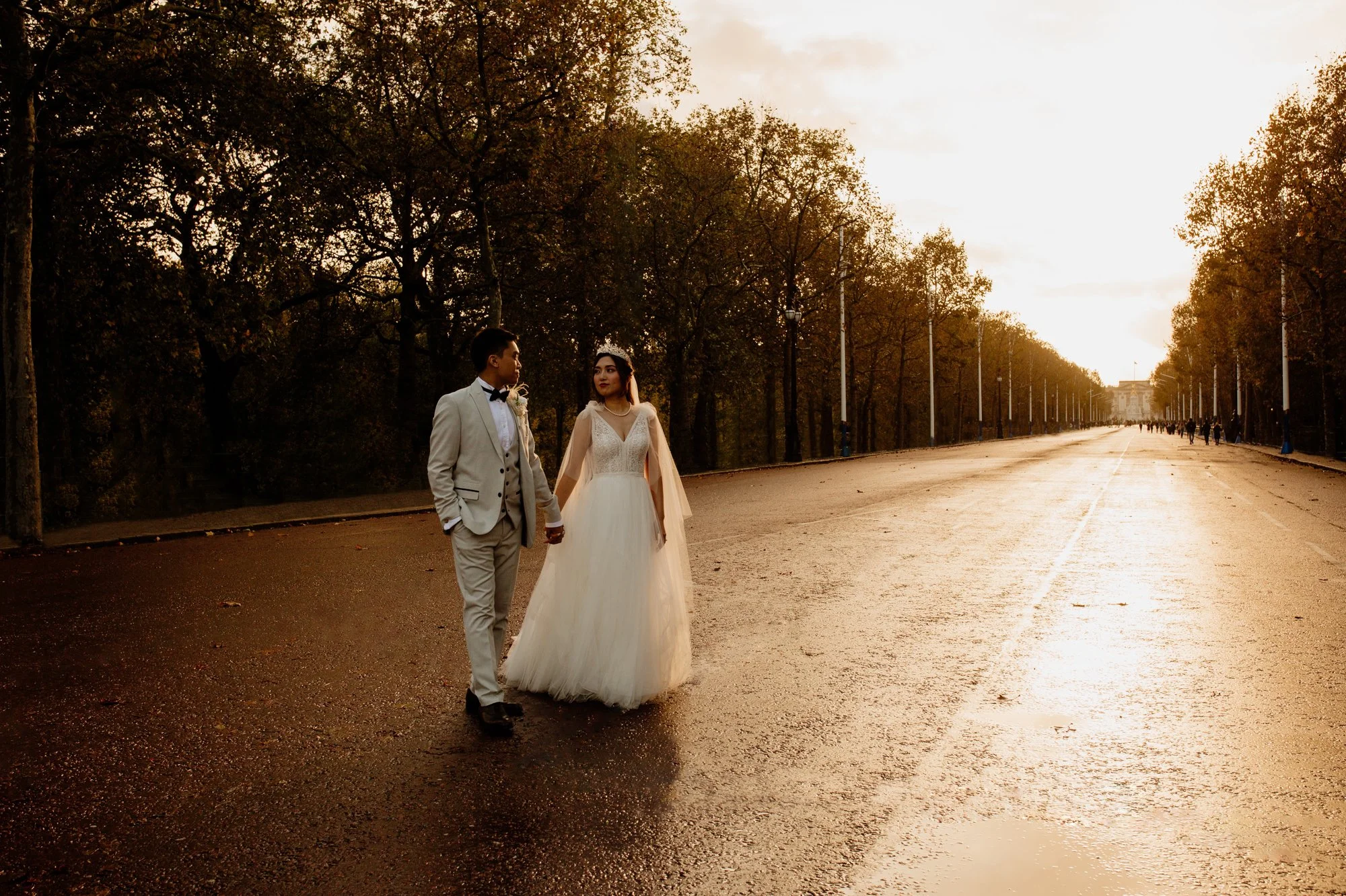A wedding couple walk down Pall Mall, Buckingham Palace in the distance.