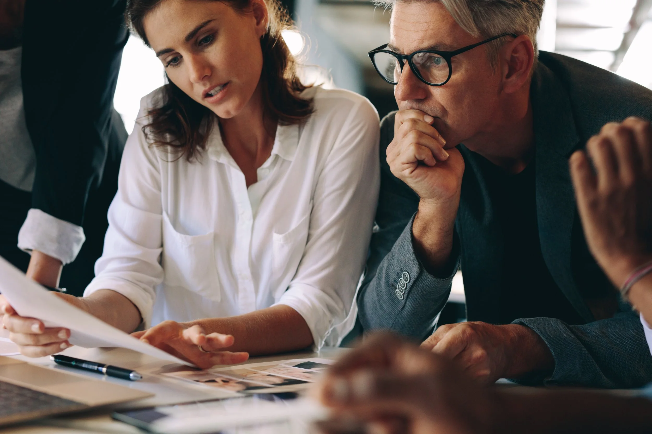 Realtor® reviewing full-service real estate marketing campaign with team members in a collaborative office setting