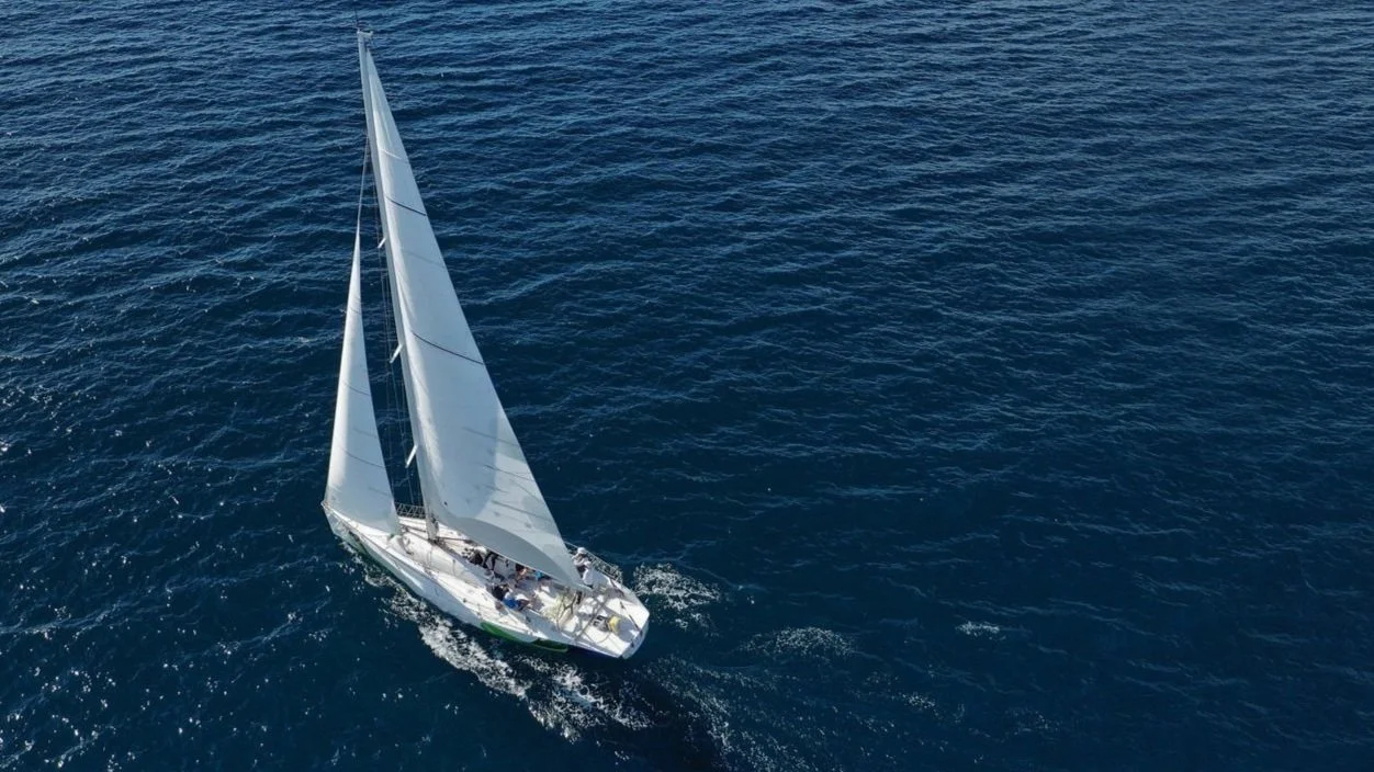 A sailboat cutting through calm ocean waters, symbolizing strategic direction and business clarity.