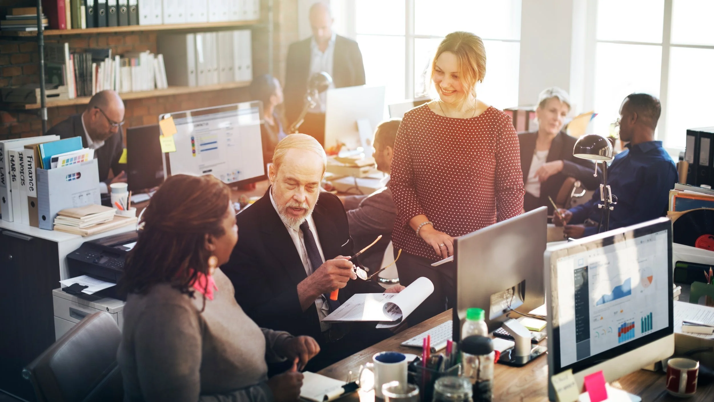 Real estate agent sitting at desk reviewing brand strategy with modern branding visuals