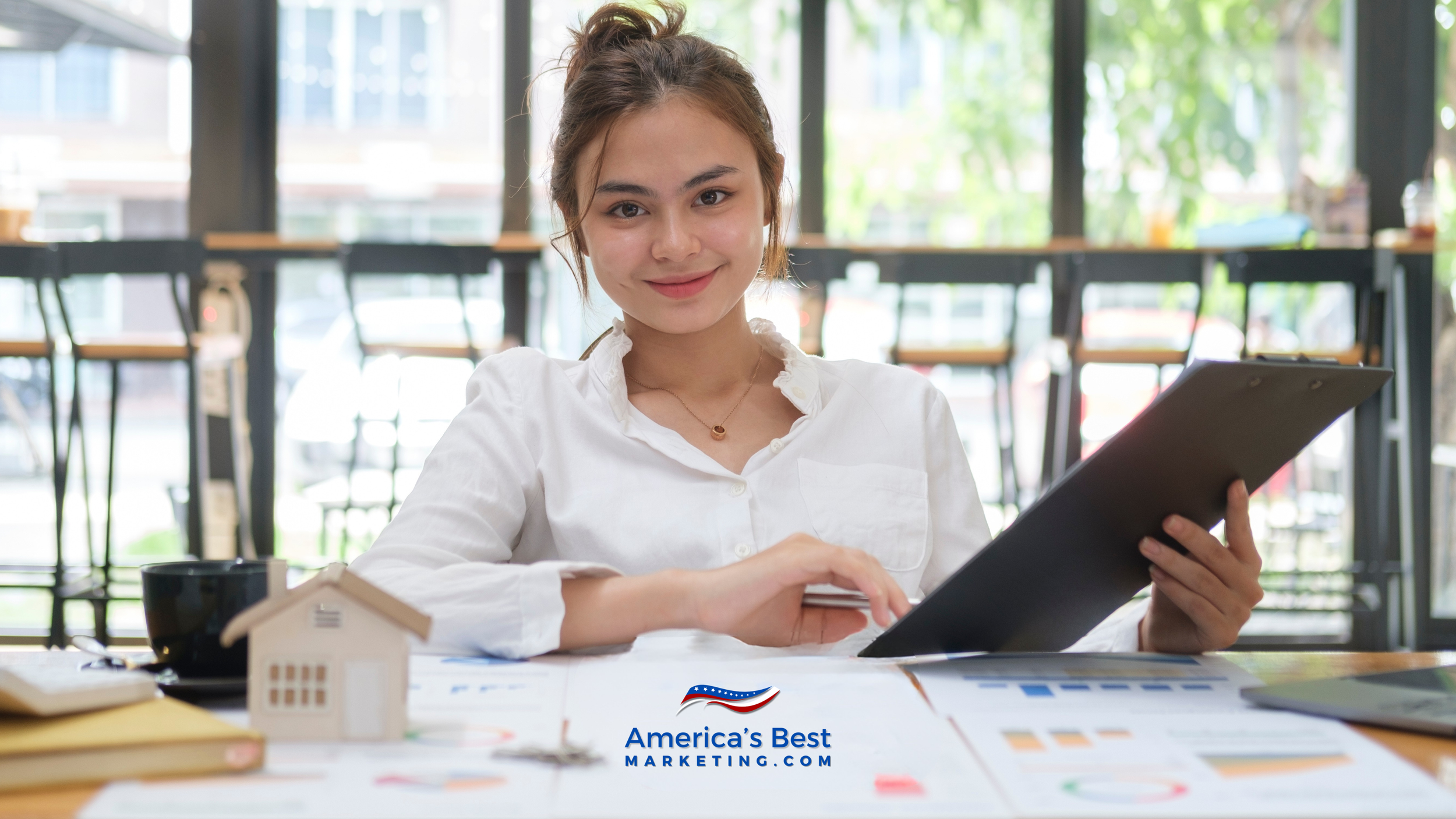 Confident new real estate agent preparing listing strategy with marketing materials at a modern office