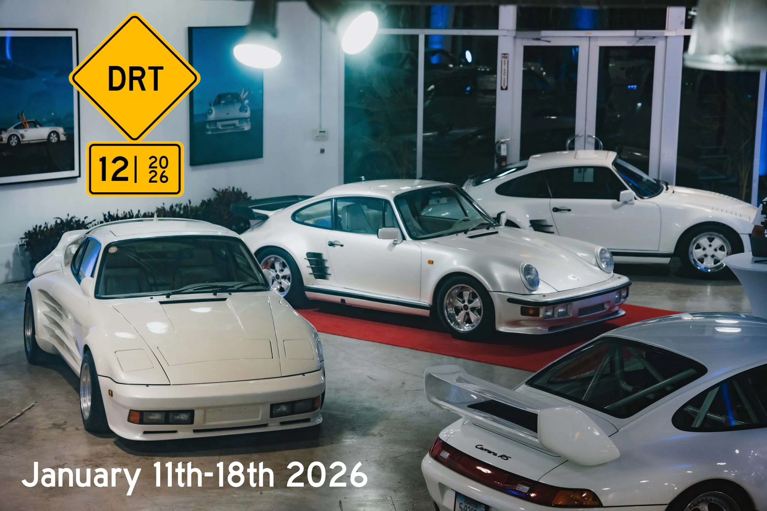 Collection of vintage Porsche cars, including 911 and 959 models, displayed indoors with signage indicating DRT event, dated January 11th-18th, 2026.