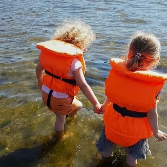 Barnehagebarn som nyter en sommerdag ved naustet ved fjorden