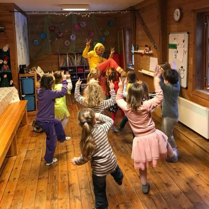 Barnehagebarn og tilsette som leikar og dansar innendørs i Aadland gards- og friluftsbarnehage