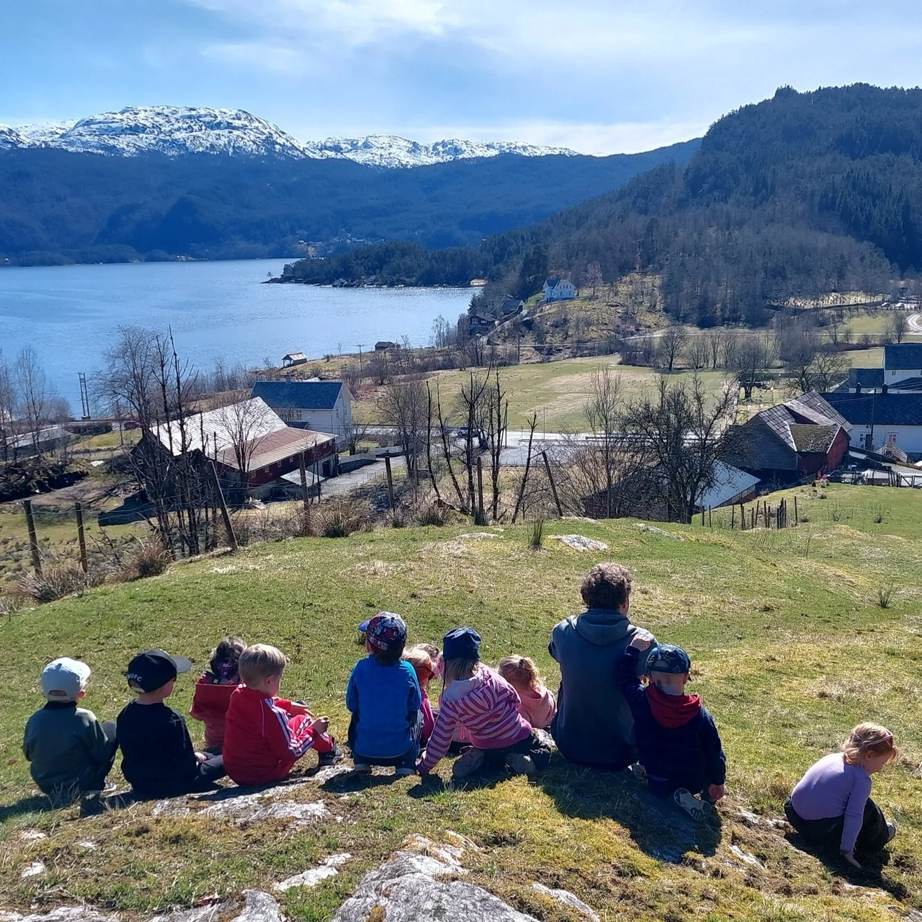 Barnehagebarn som ser utover fjorden og garden i Aadland gards- og friluftsbarnehage