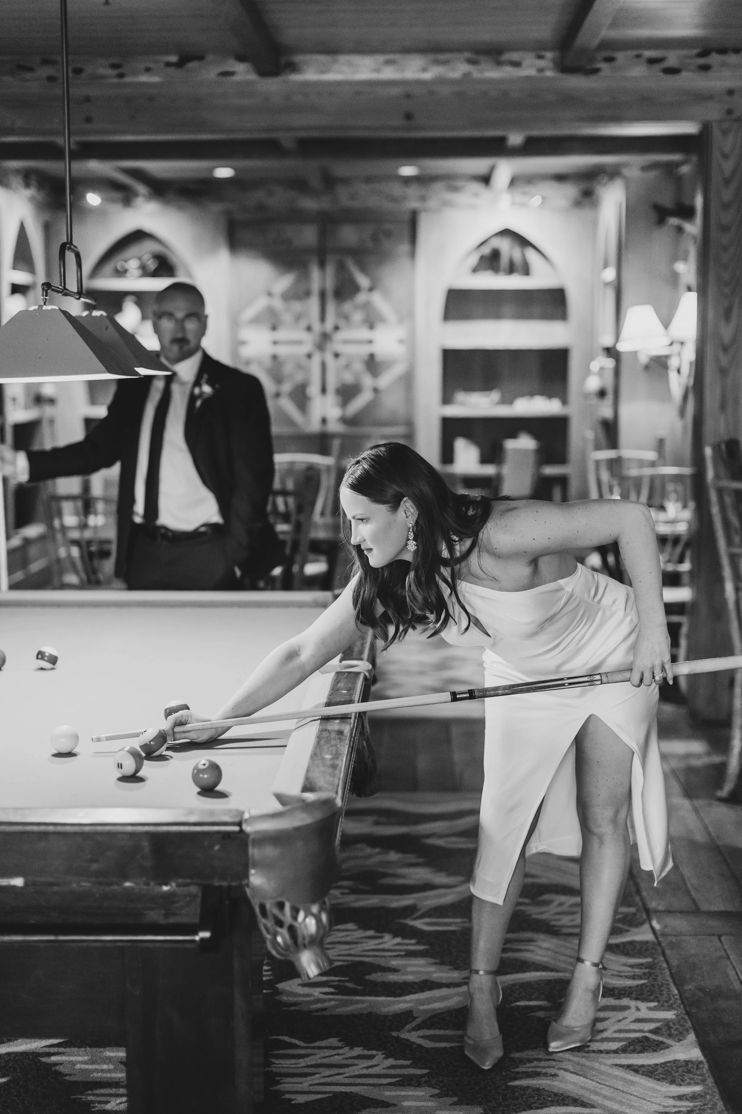 Couple playing pool during their winter elopement at Lake Placid Lodge