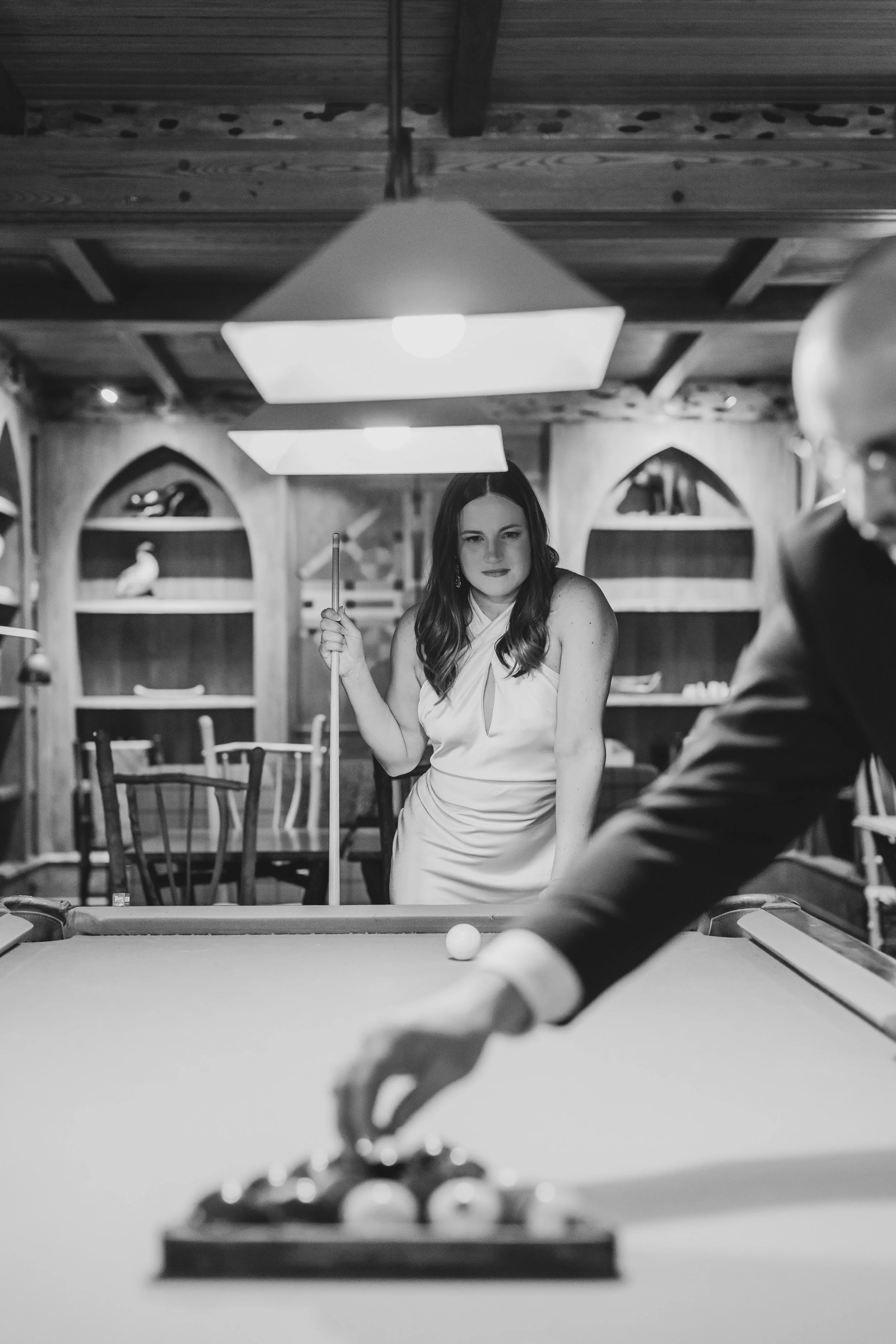 Couple playing pool during their winter elopement at Lake Placid Lodge