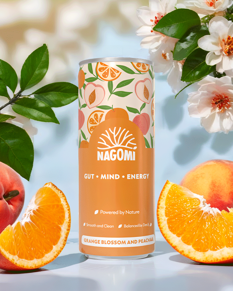 Can of Nagomi Orange Blossom and Peach Drink surronded by orange blossom and fruit.