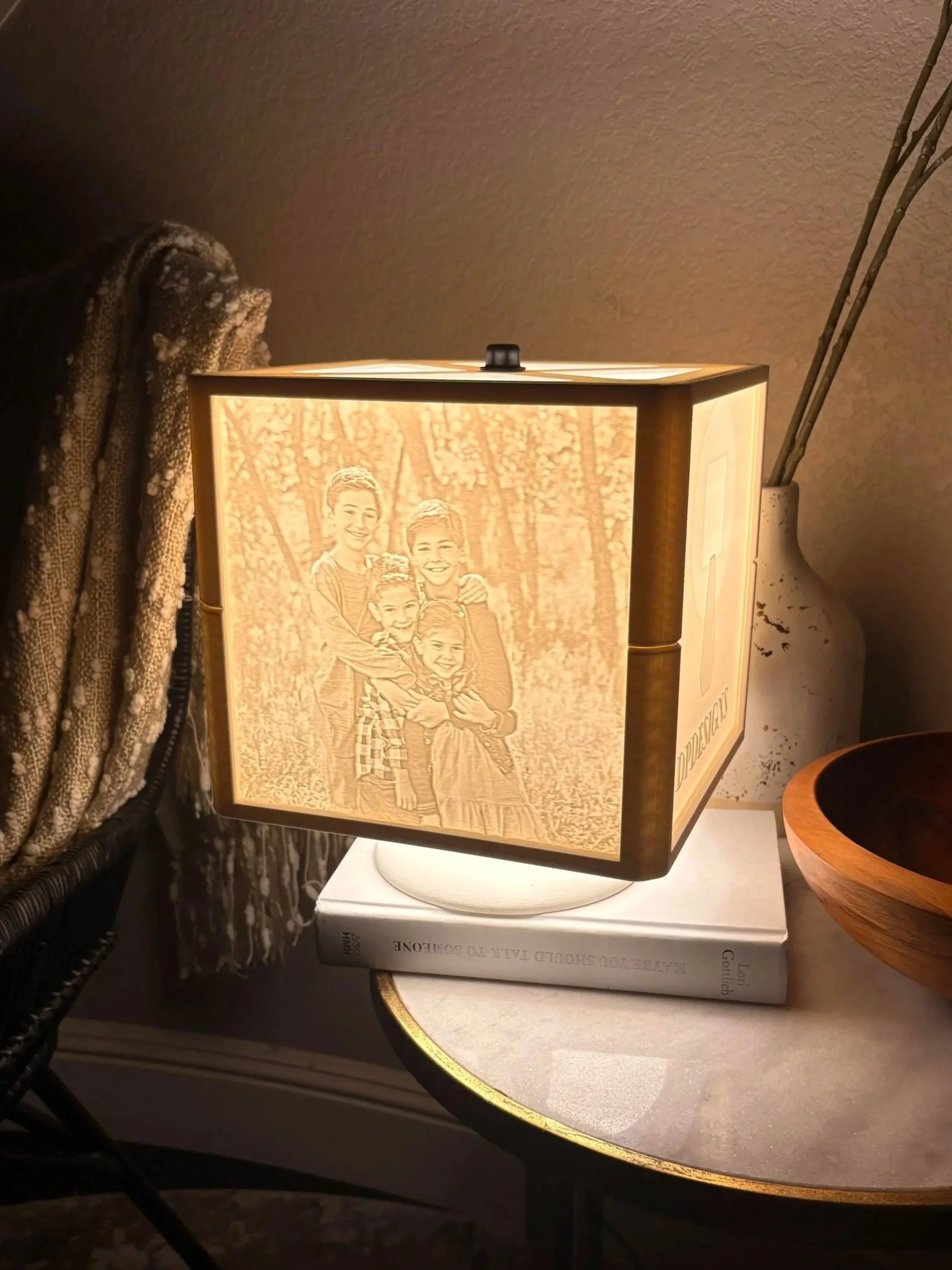 Table lamp with a beatiful picture of a dog on its shade, placed on a wooden shelf with a white ceramic tile pattern.