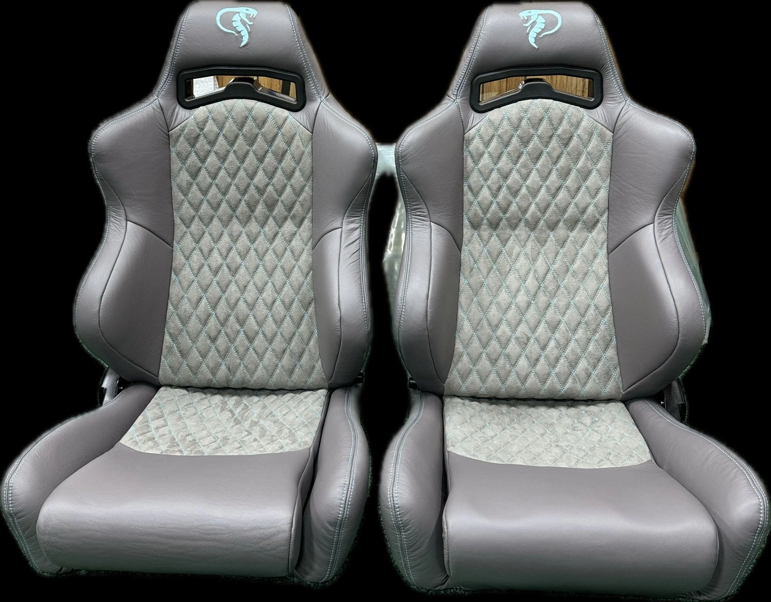 Pair of car racing seats with grey upholstery and a quilted fabric pattern in the center, with a black background