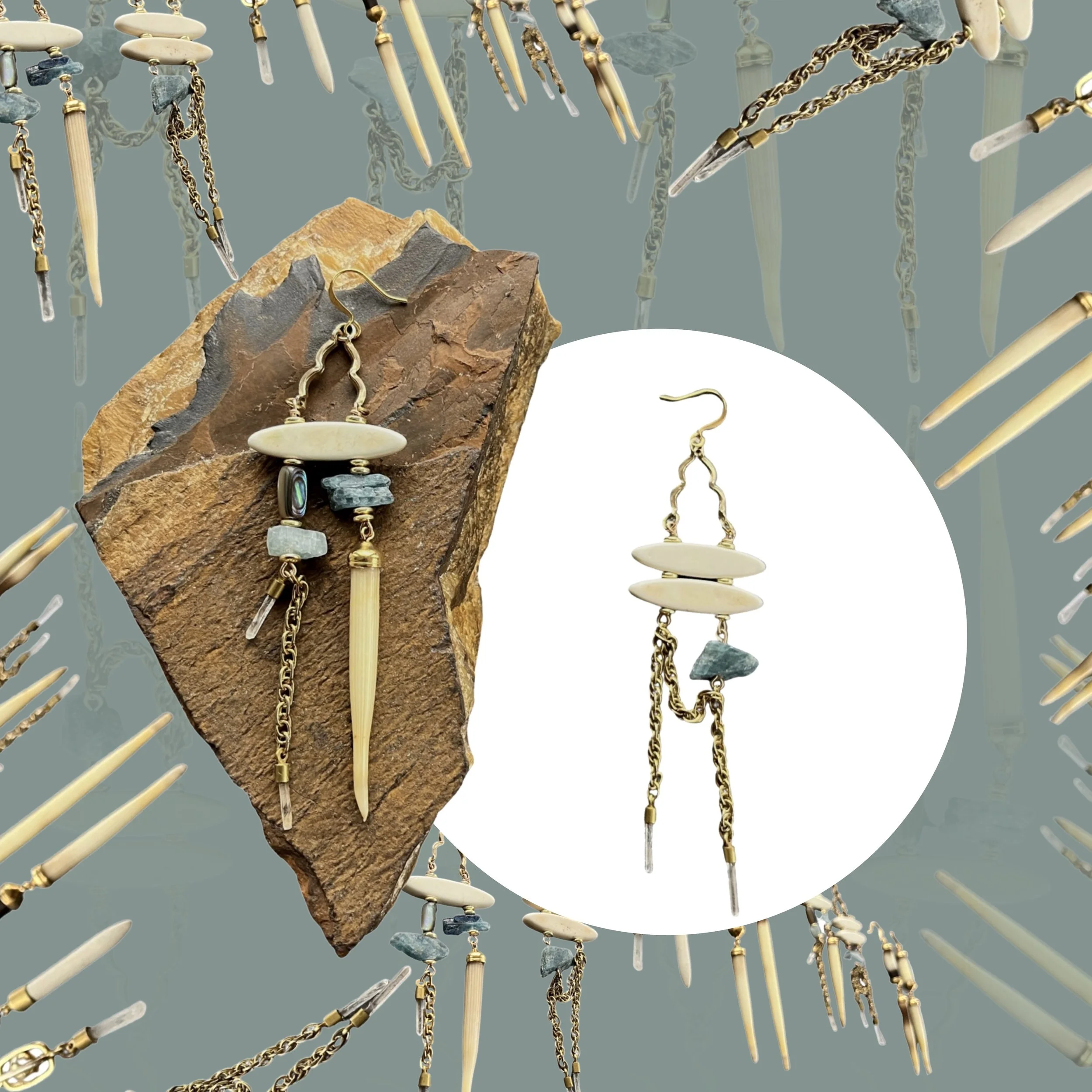 Artistic earring display with natural stones and chains on a rock background