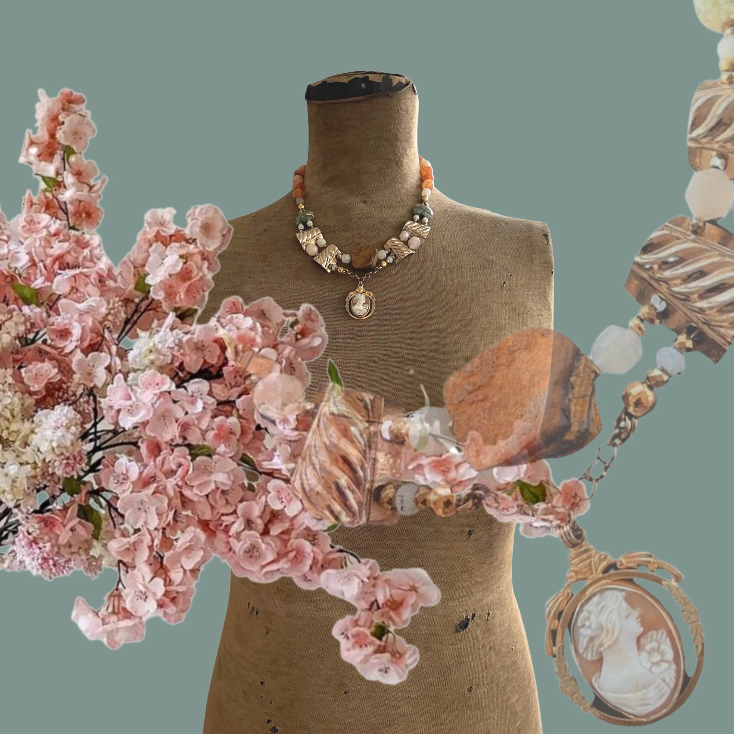 Mannequin adorned with a vintage-style necklace surrounded by blossoming pink flowers on a muted green background.
