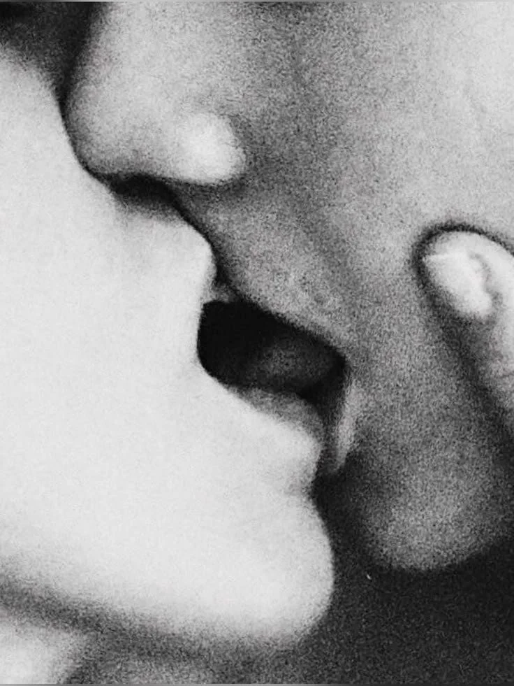 Close-up of two people kissing, black and white photo.
