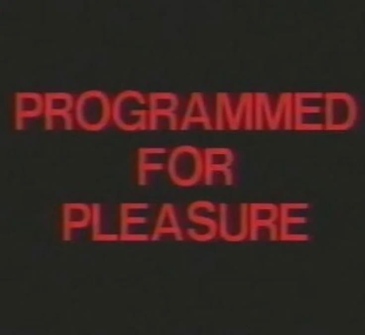 Red text on black background reads "PROGRAMMED FOR PLEASURE."