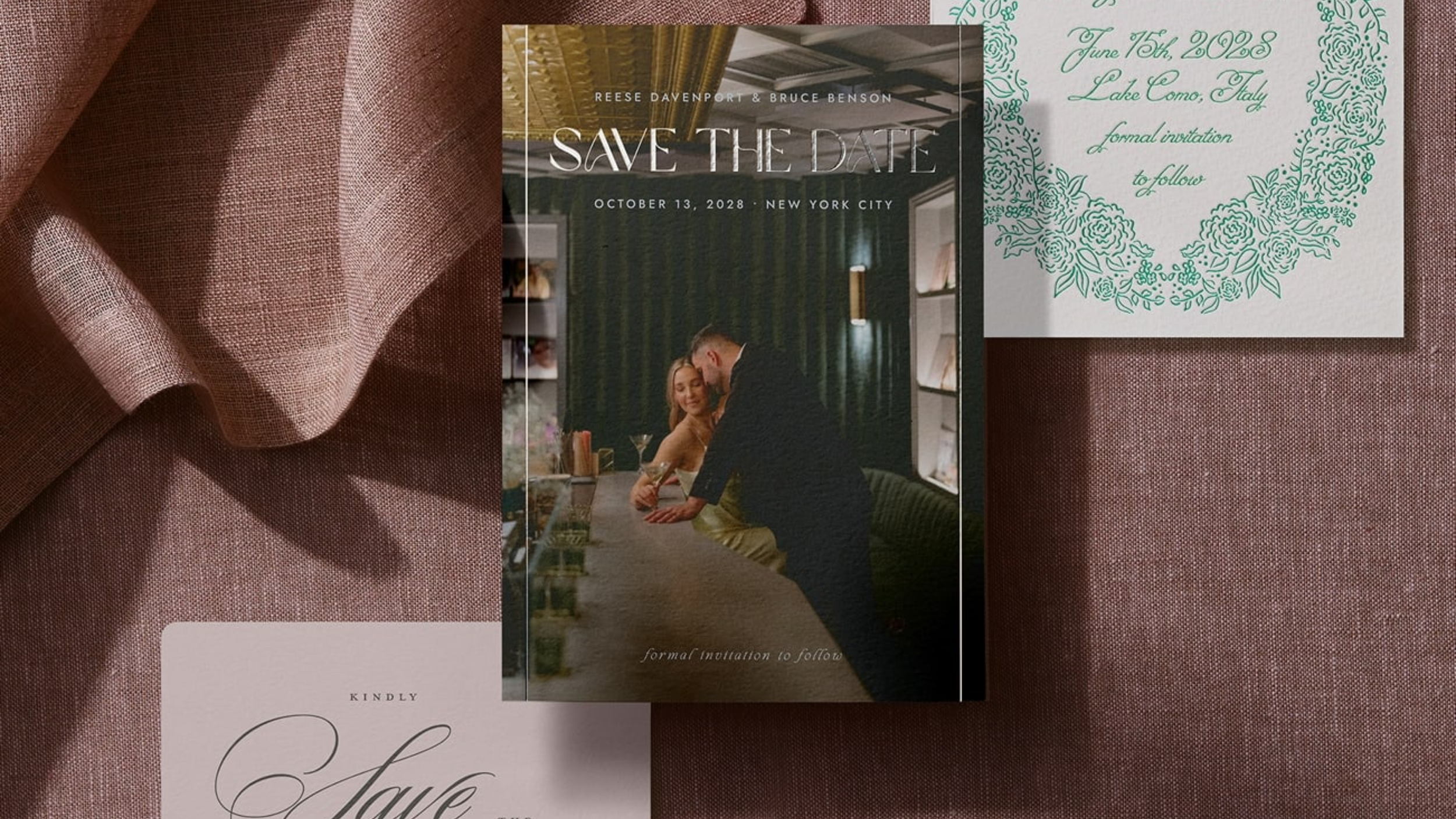Save the date card featuring a photo of a couple at a bar, with the text "Save the Date" and event details. There are also additional invitation cards with floral designs and elegant script on a textured mauve fabric background.
