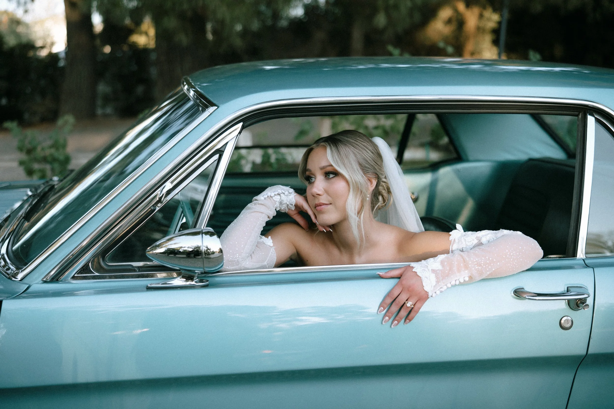 Wedding portrait of bride in vintage car at Lake Oak Meadows in Temecula