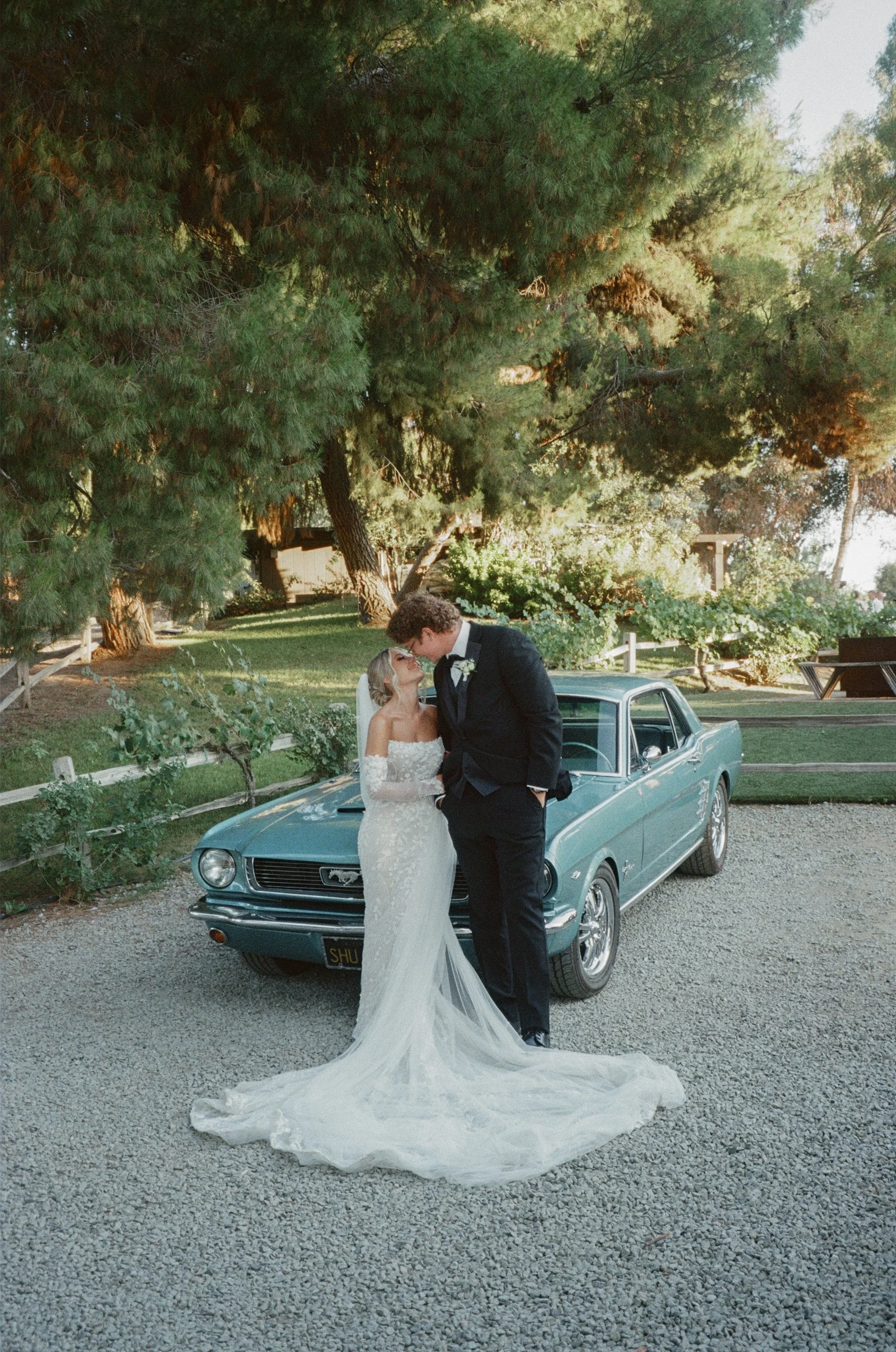Bride and groom captured on film at a Temecula wedding venue lake oak meadows featuring a vintage car