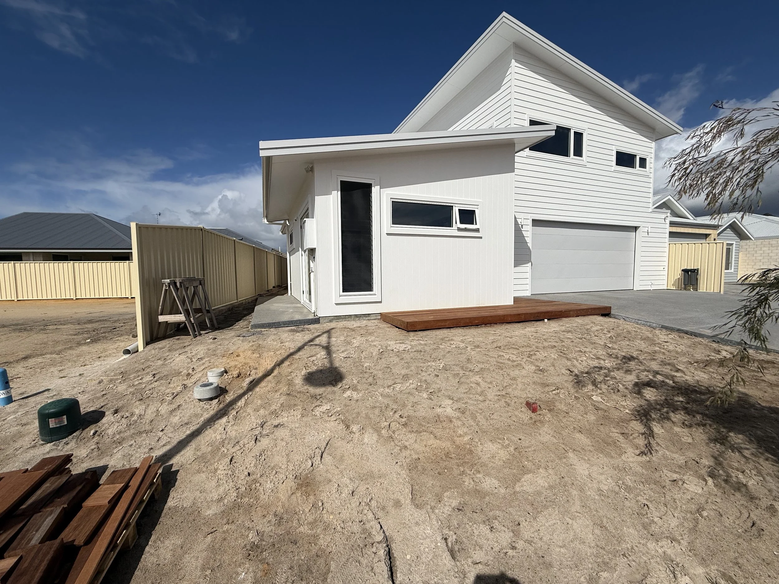 A vacant garden space in front of a new build coastal home.