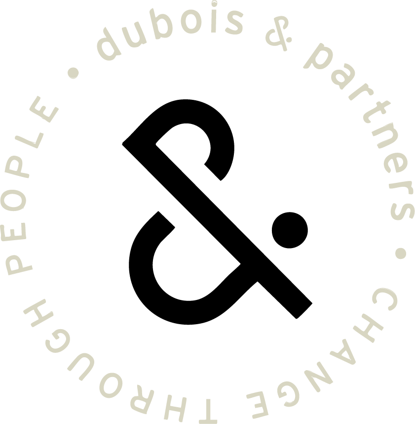 Een zwart logo met cirkelvormige tekst: 'plE dUBois & p. PARTNERS CHANGING THE PEOPLE OF DUBOIS'.