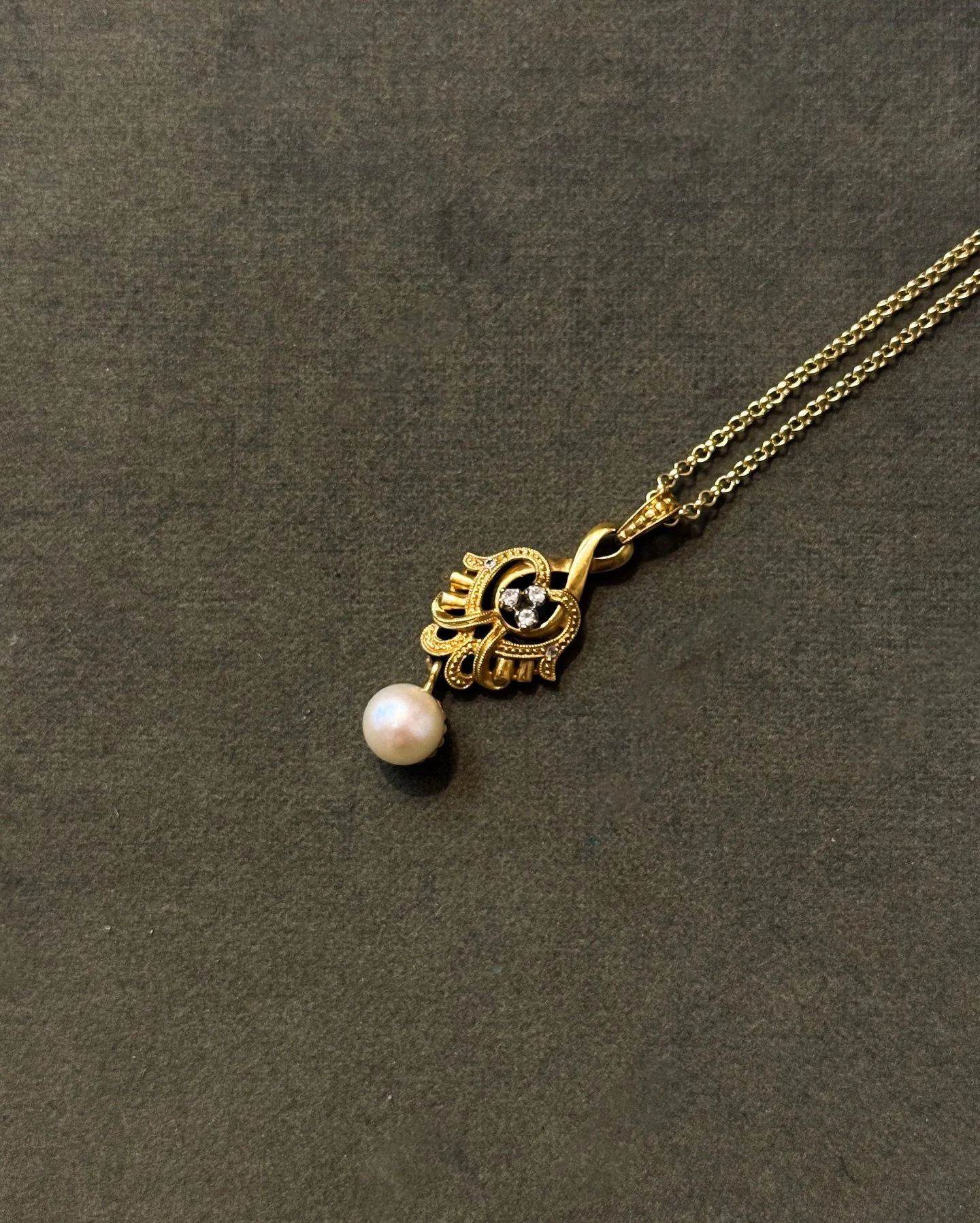 Ein feines Vintage-Collier aus Gelbgold, verziert mit einem kleinen Diamanten und einer schimmernden Perle. Die harmonische Verbindung aus warmem Gold und k&uuml;hlem L&uuml;ster verleiht diesem Anh&auml;nger eine zeitlose Eleganz &ndash; zart, ausge