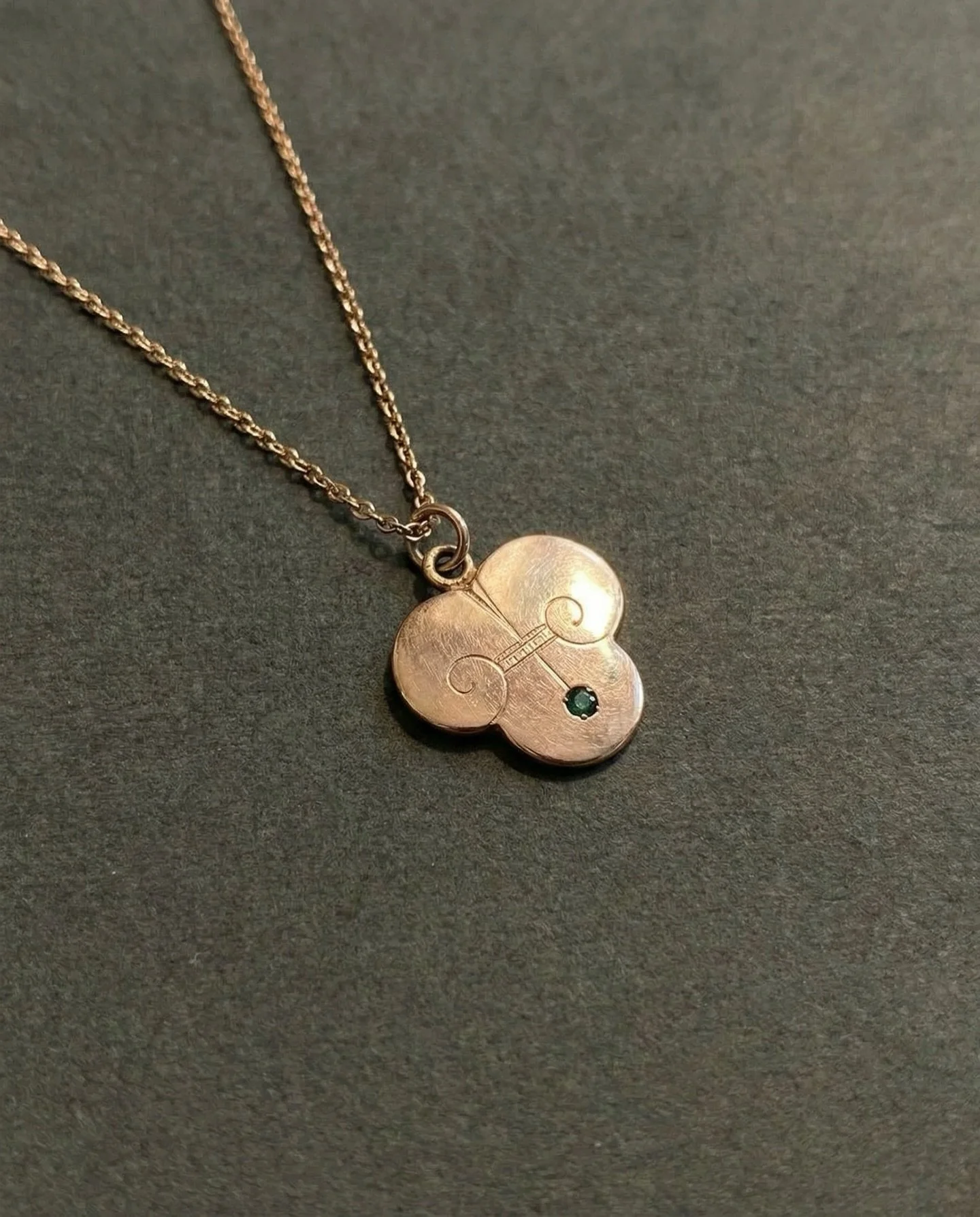 Diese Kombination aus Kette und Anh&auml;nger entstand um 1890 und l&auml;sst sich stilistisch dem fr&uuml;hen Jugendstil zuordnen, einer Epoche, in der naturbezogene Motive und flie&szlig;ende Linien bewusst als Gegenentwurf zum Historismus eingeset