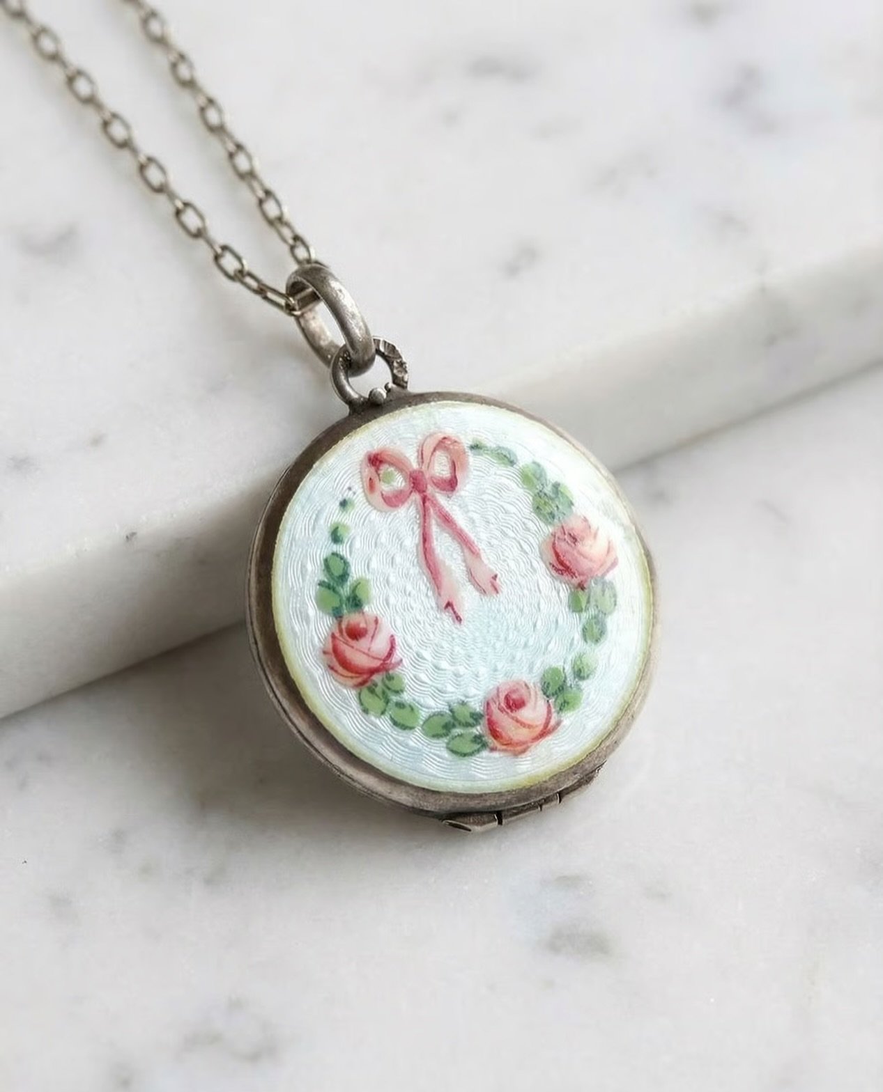 Dieses elegante Medaillon aus Frankreich um 1920 ist ein herausragendes Beispiel f&uuml;r die kunstvolle Guilloch&eacute;-Emaille-Technik. Die Oberfl&auml;che des Silbers wurde durch feine, maschinell gravierte Wellenlinien strukturiert, bevor eine t