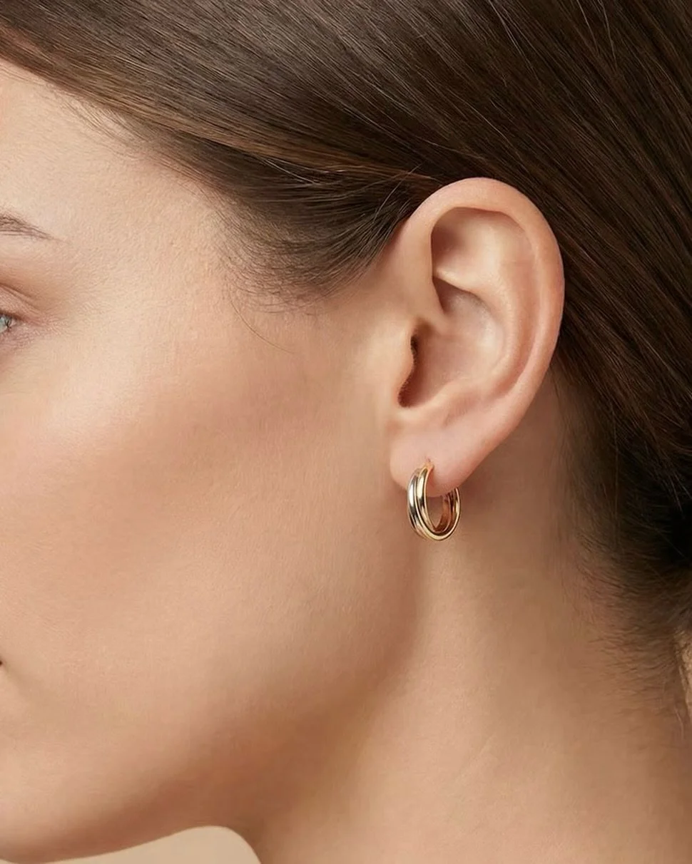 Dieses Paar Ohrringe stammt aus Deutschland und wurde in den 1960er Jahren von einer Meistergoldschmiede gefertigt. Die Gestaltung greift das klassische Trinity-Motiv auf, das aus drei ineinander verschlungenen Goldelementen in Gelbgold, Ros&eacute;g