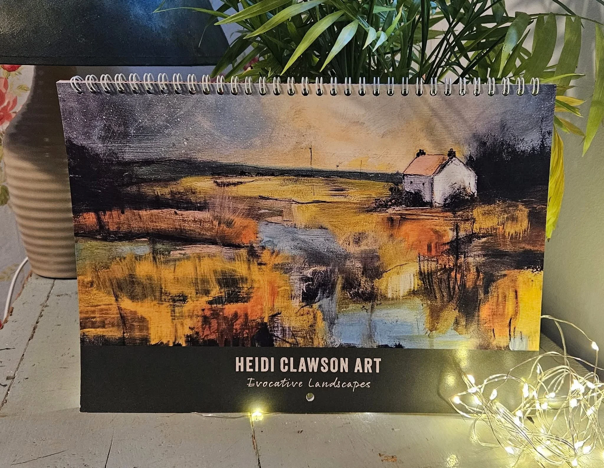 Calendar with Heidi Clawson landscape art in a festive setting