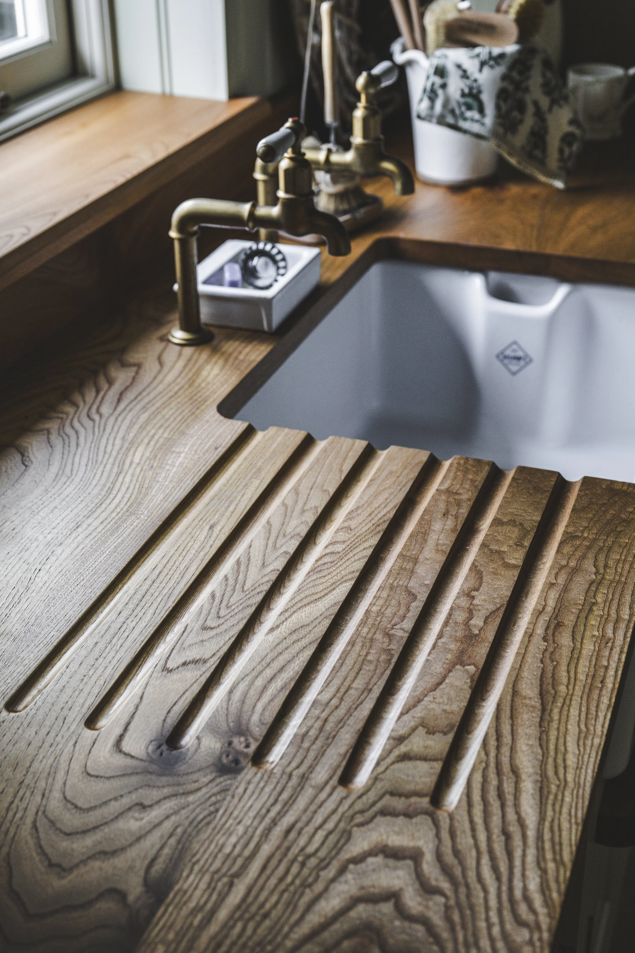 Solid wood draining board with perrin and rowe taps