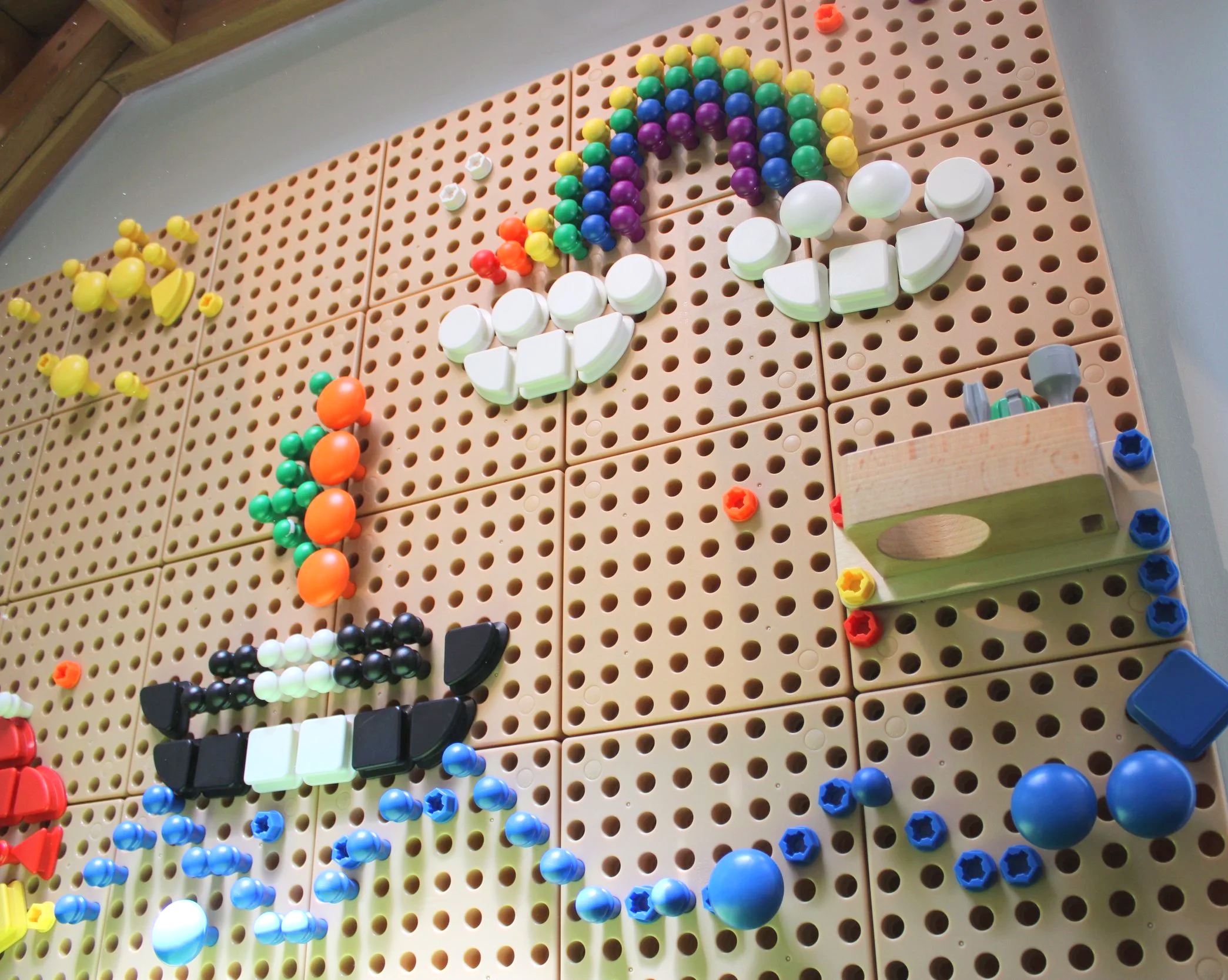 Colorful plastic beads and objects arranged on a pegboard