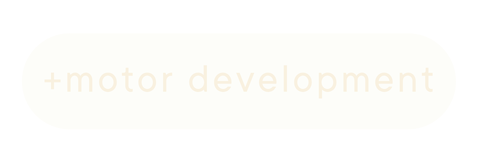 A beige pill capsule with simple rounded edges, featuring the text 'motor development' written faintly across it.