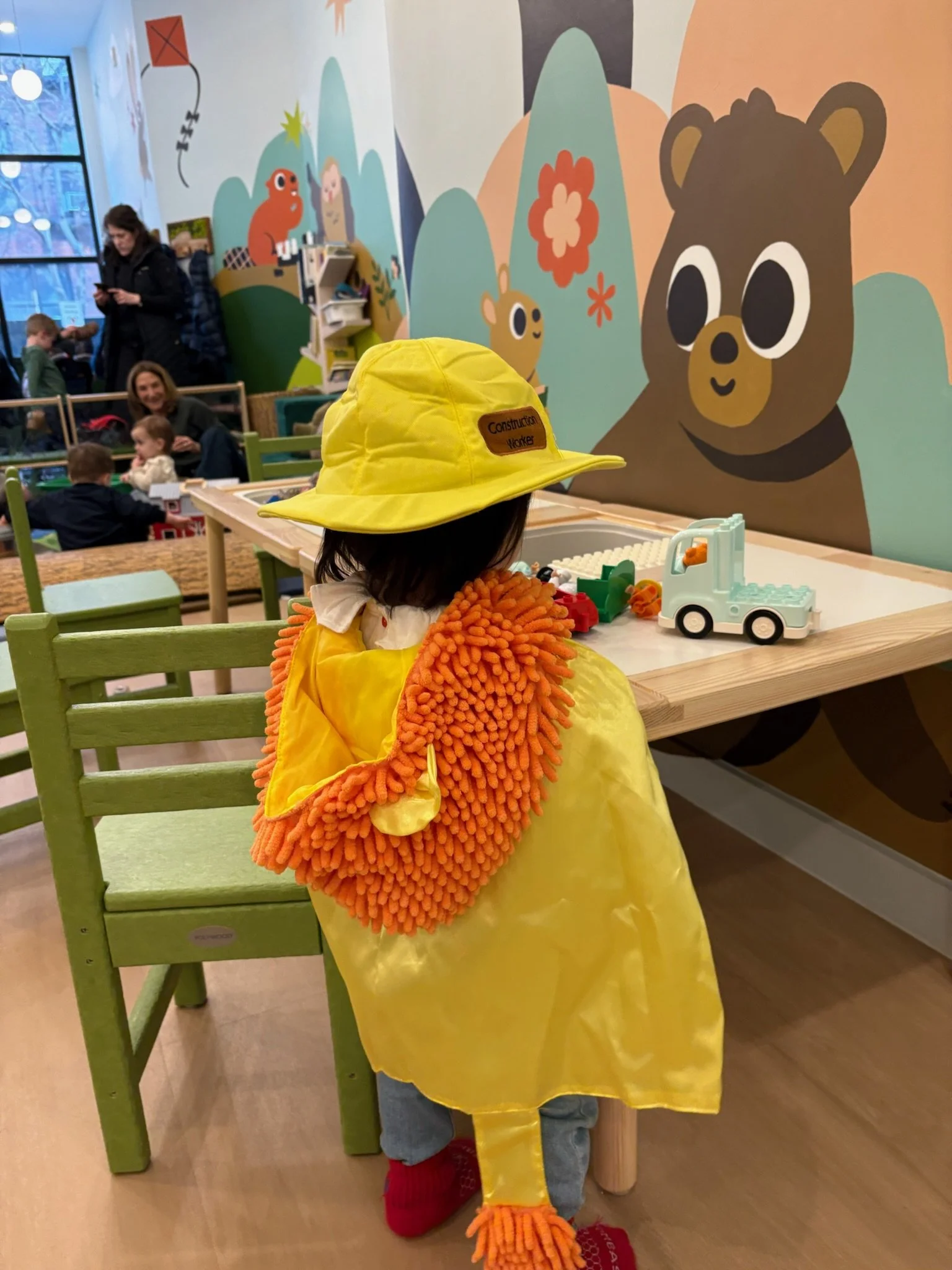 a child wearing a lion costume plays with a sensory box in Chelsea NYC